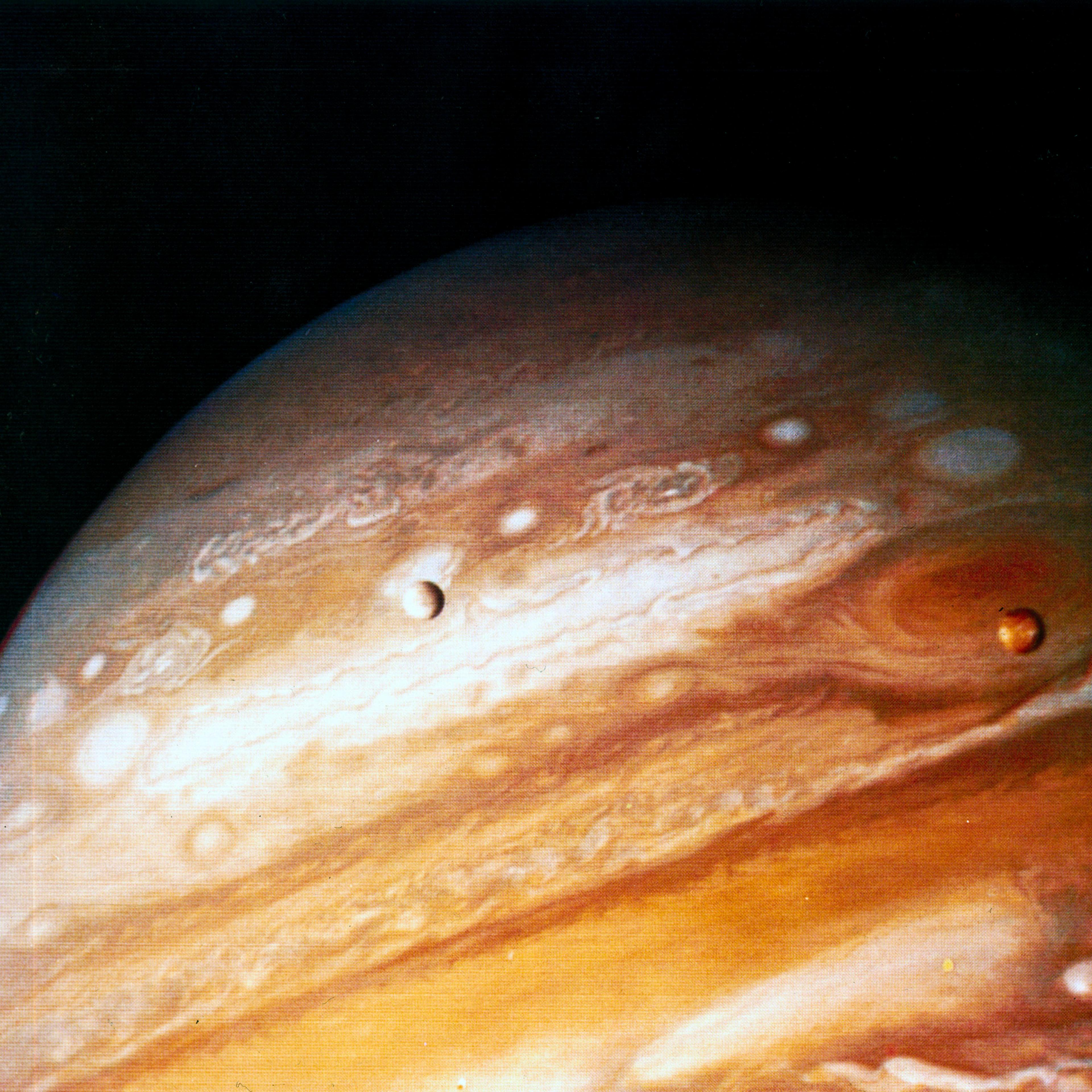 The planet Jupiter, showing two of its moons and the Great Red Spot, 1979.