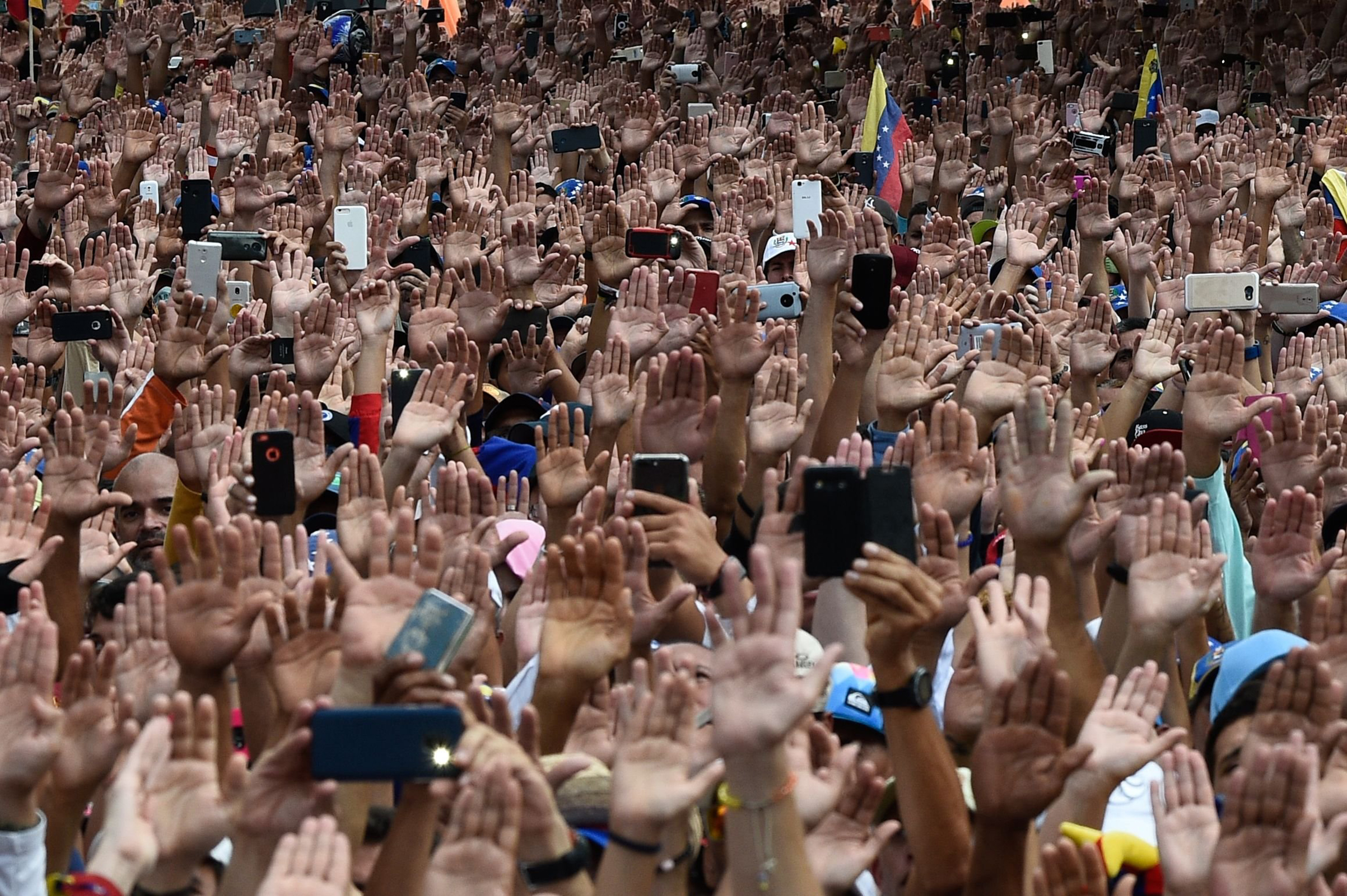 People raise their hands during a massive anti-government rally against Venezuelan President Nicolás Maduro.