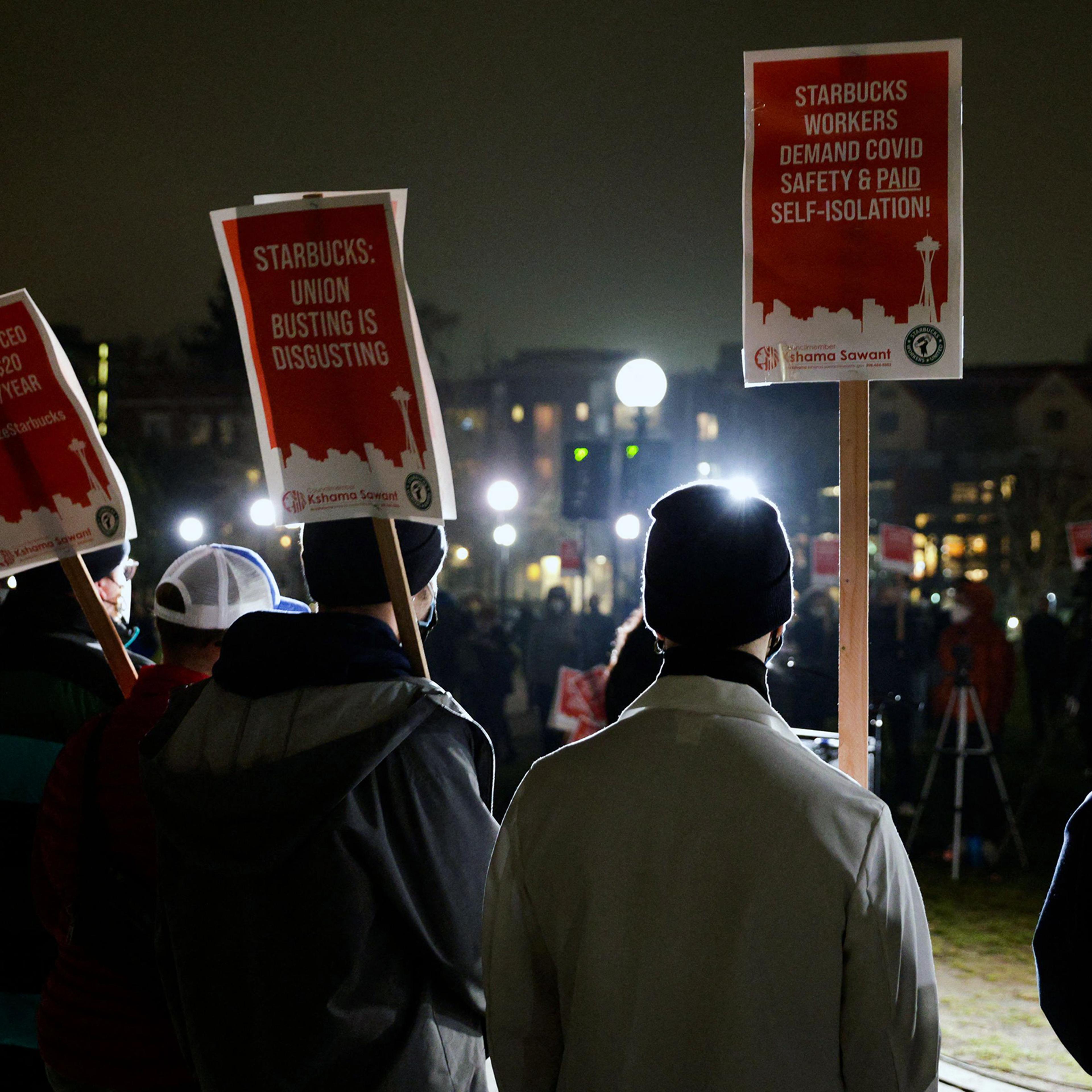 Representatives from local unions hold signs in support of workers of two Seattle Starbucks locations that announced plans to unionize, during an evening rally at Cal Anderson Park in Seattle, Washington, January 25, 2022.