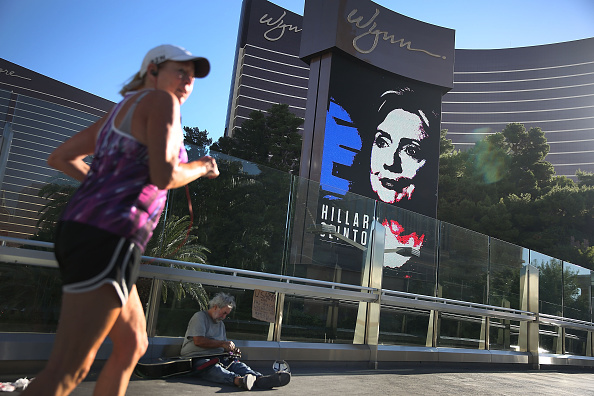 Michael McLean sets up to play his guitar for money near a billboard showing a picture of Democratic Presidential candidate Hillary Clinton advertising the upcoming Democratic Presidential debate at the Wynn Las Vegas resort and casino on October 12, 201
