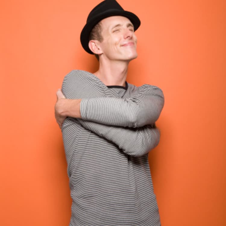 man-hugging-self-smiling