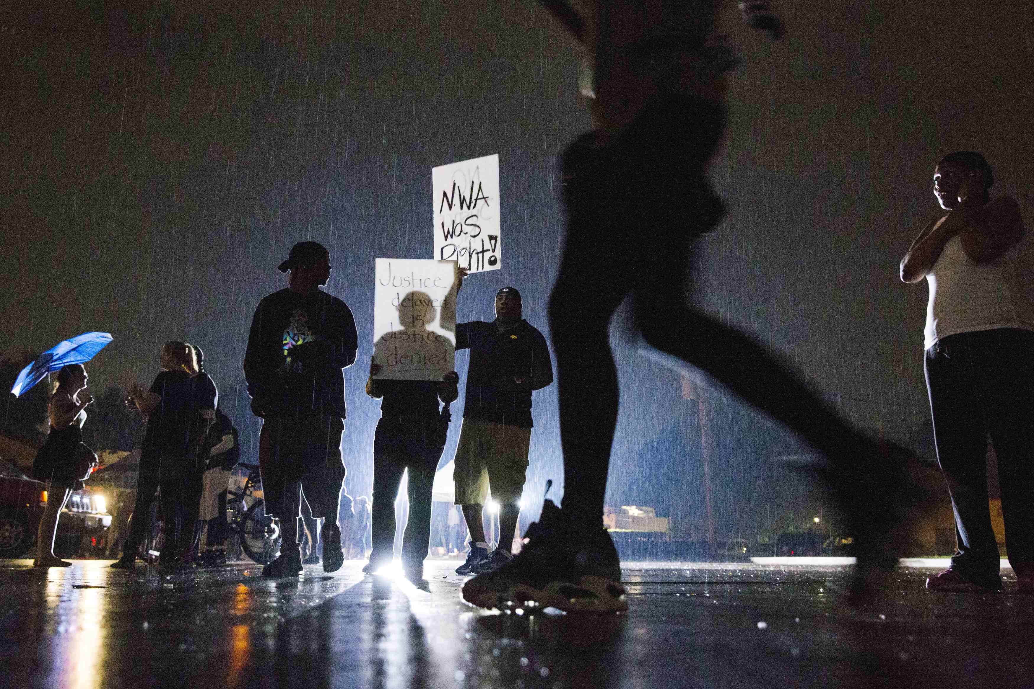 Protesters hold signs during a demonstration to protest the shooting of Brown and the resulting police response in Ferguson