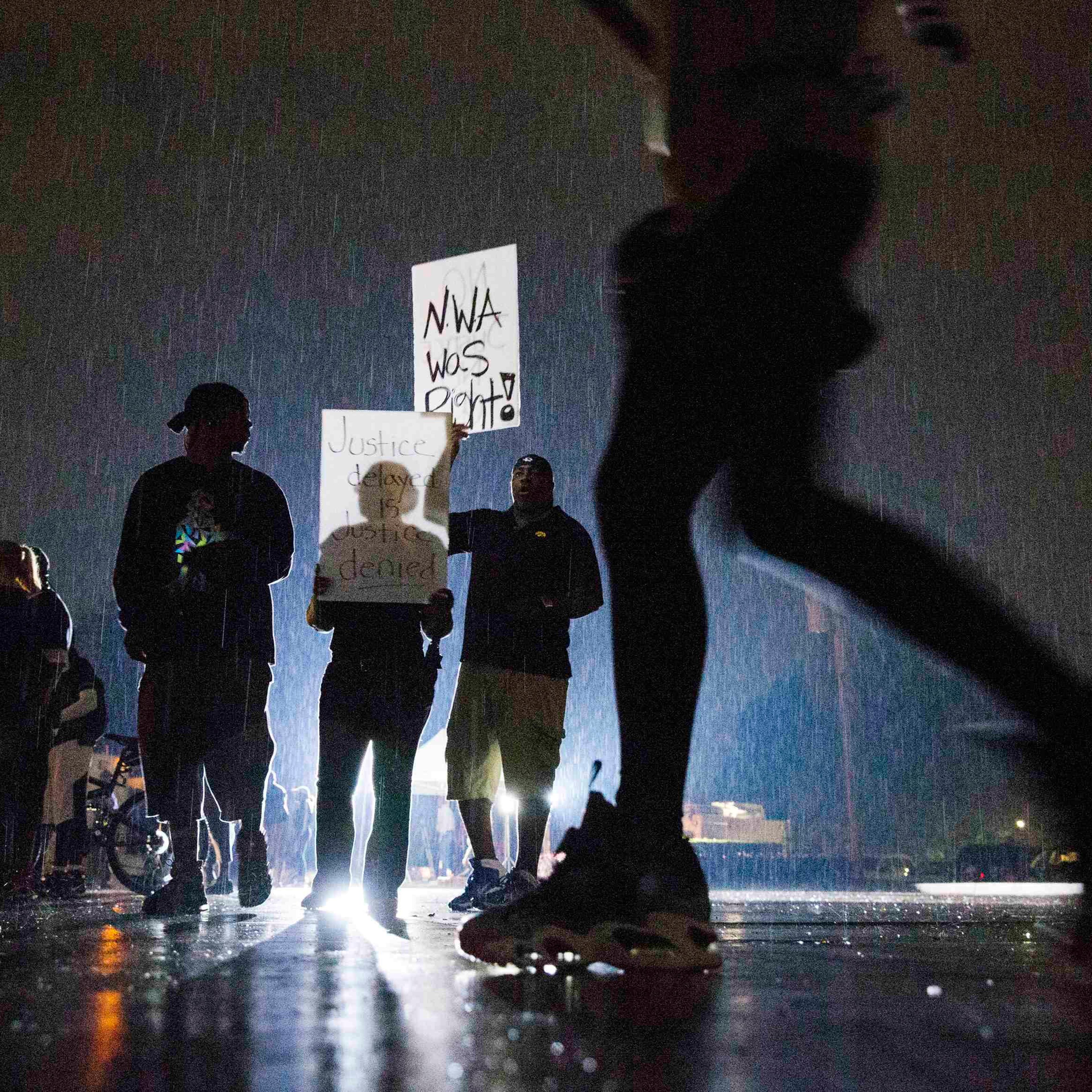Protesters hold signs during a demonstration to protest the shooting of Brown and the resulting police response in Ferguson