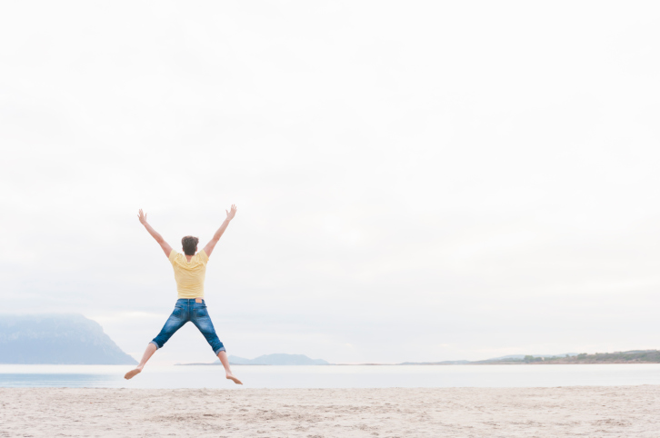 Man jumping in mid air on beach