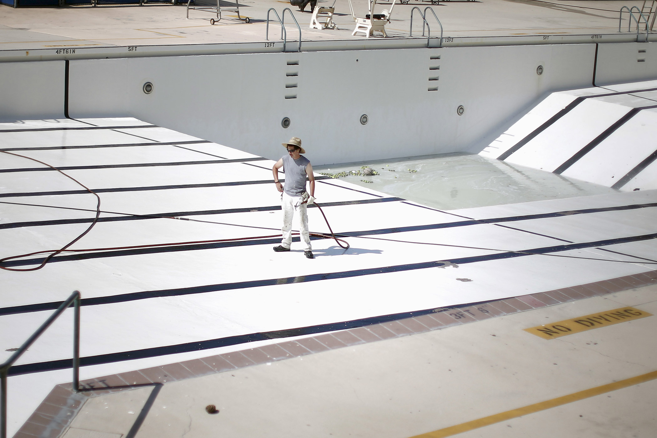 A man stands in an empty public swimming pool in Burbank, Los Angeles, California.