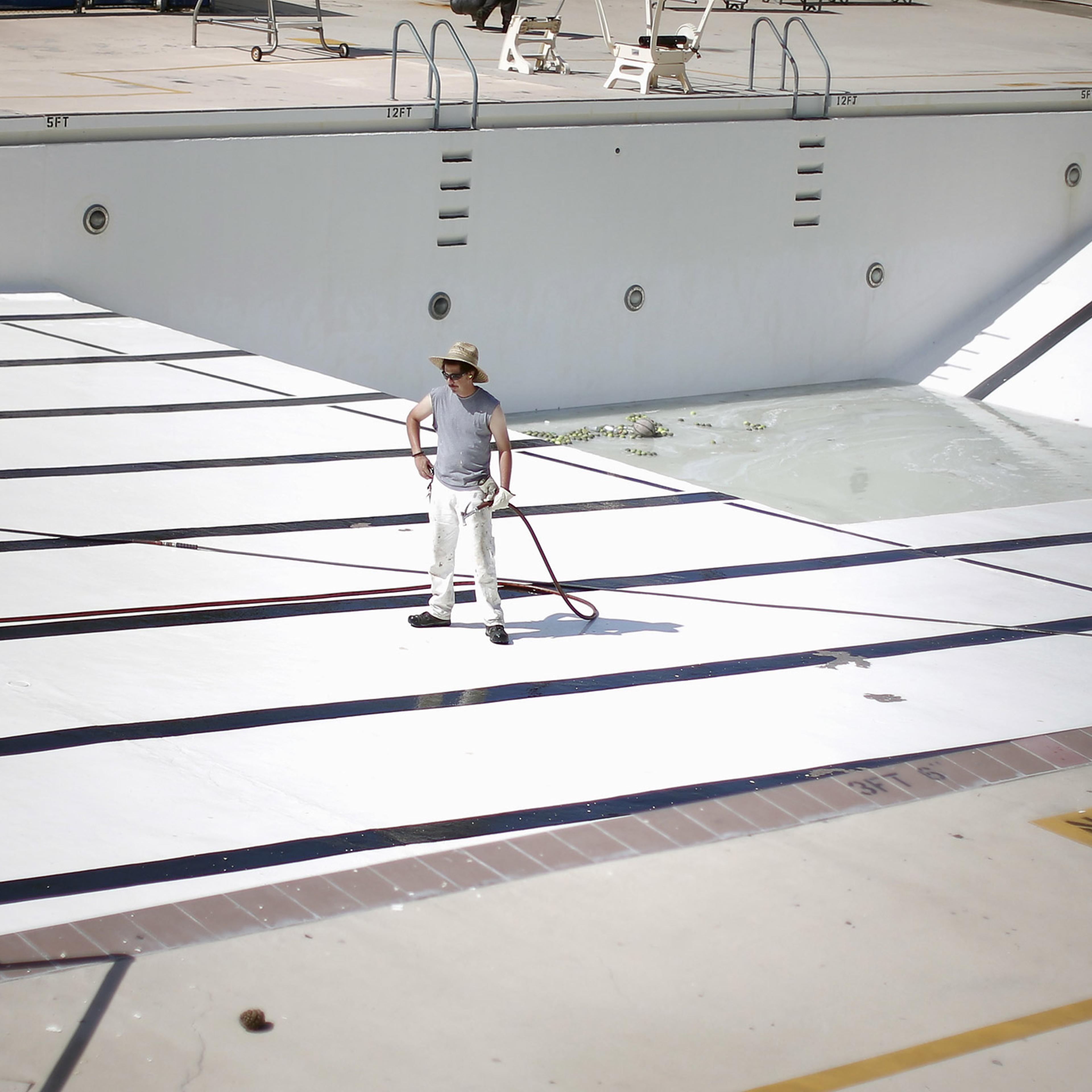 A man stands in an empty public swimming pool in Burbank, Los Angeles, California.