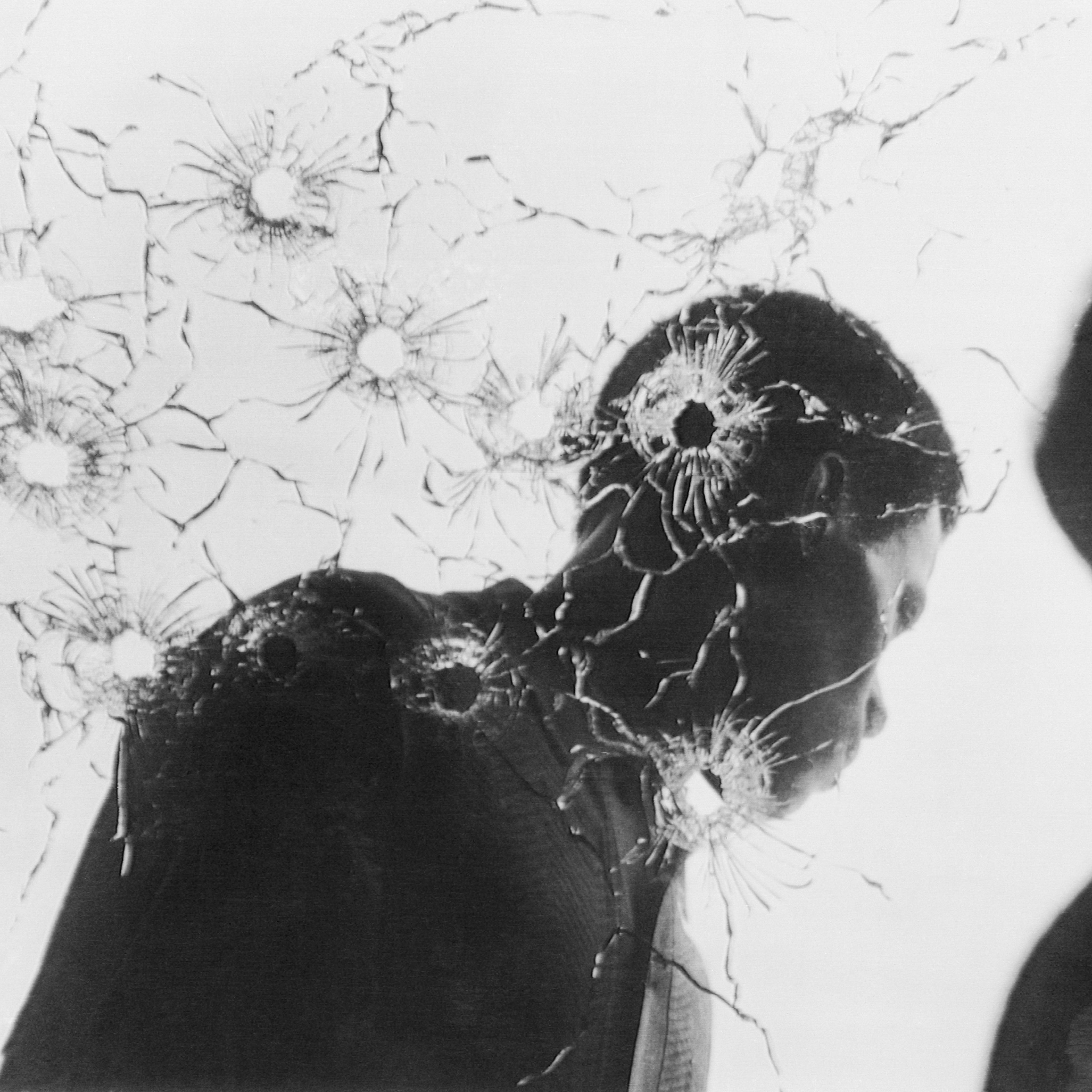 Man Behind Bullet-Riddled Glass