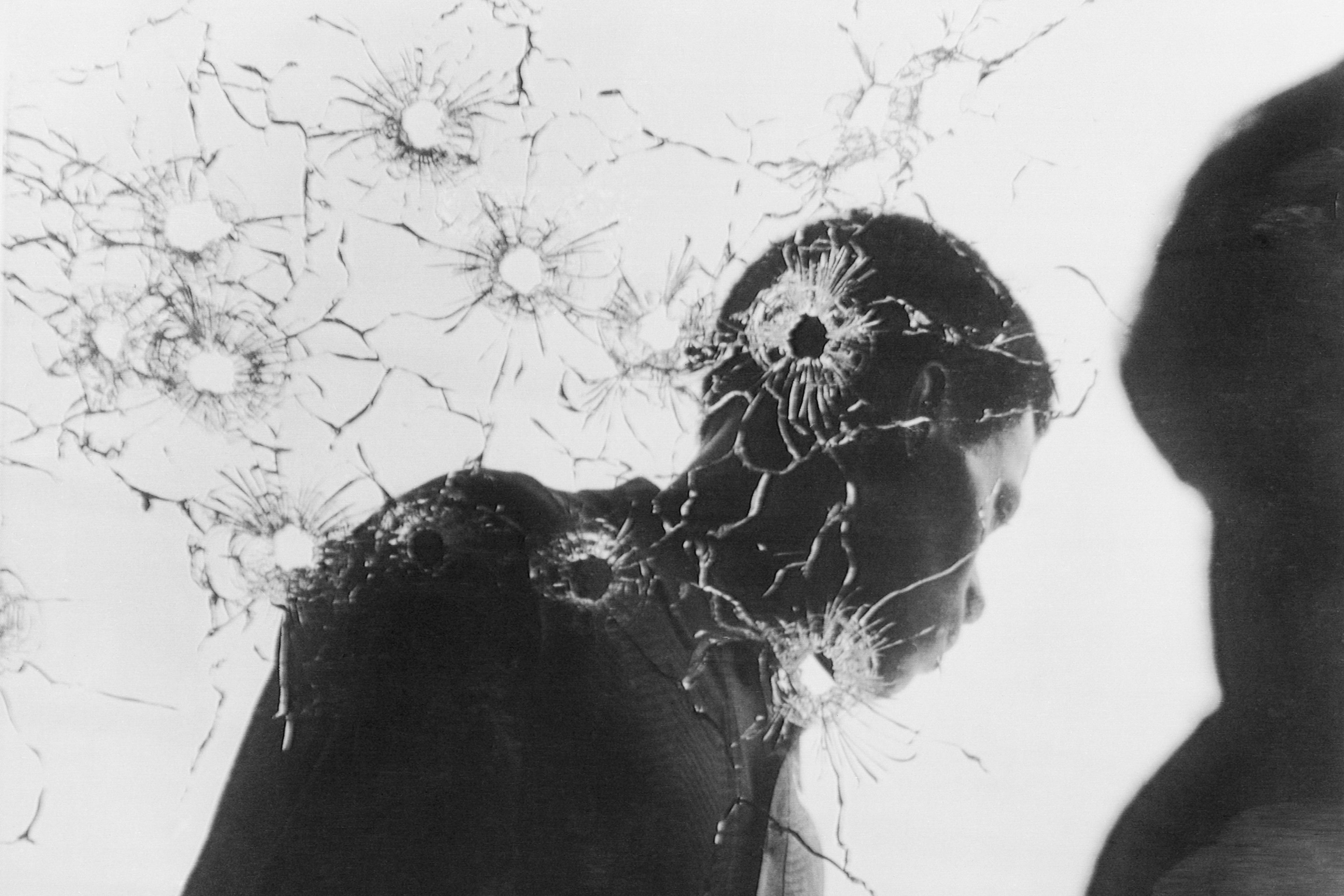 Man Behind Bullet-Riddled Glass