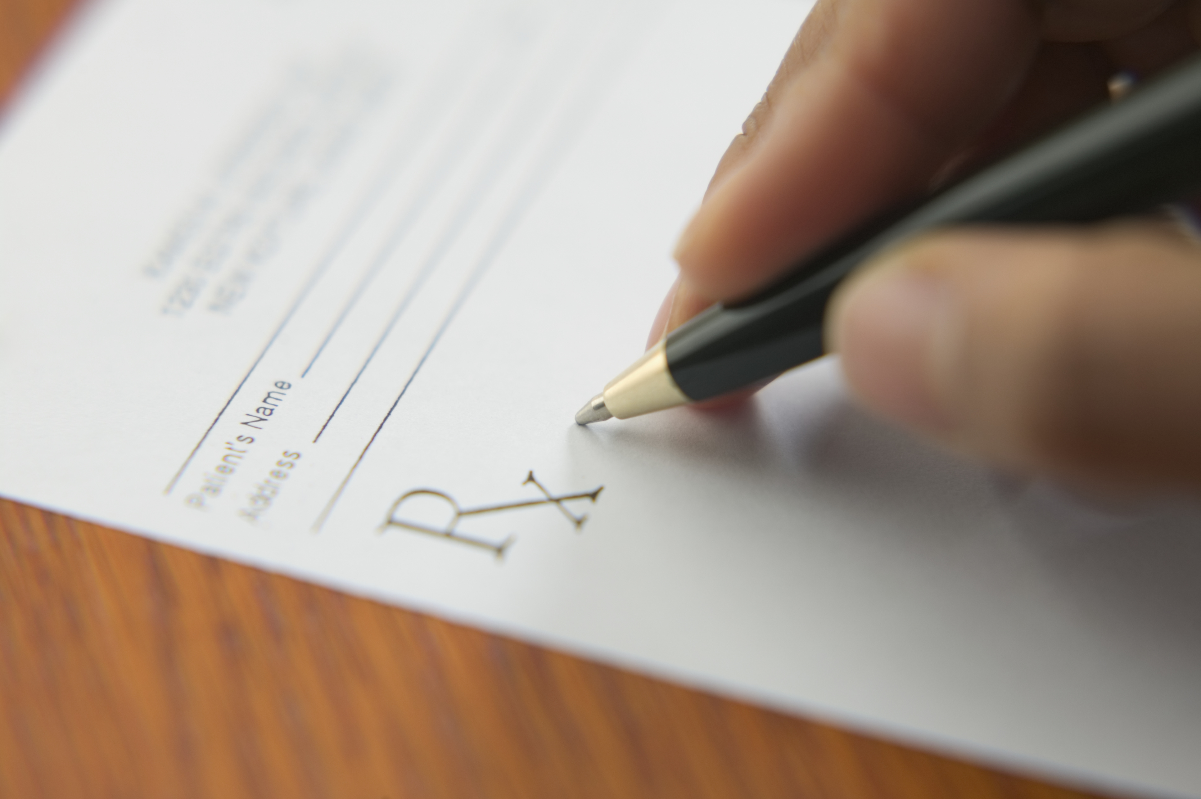 Close up of hand writing prescription