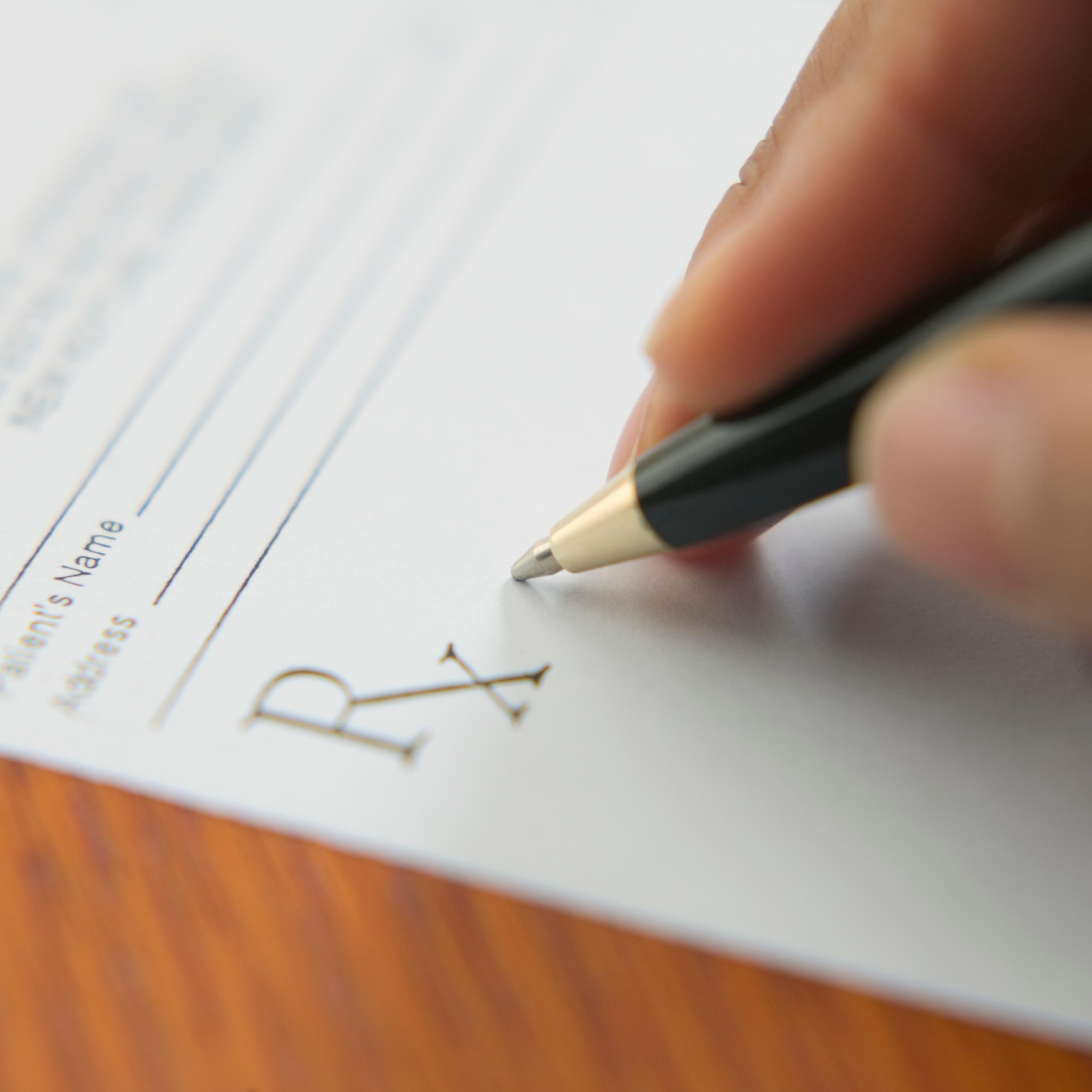 Close up of hand writing prescription