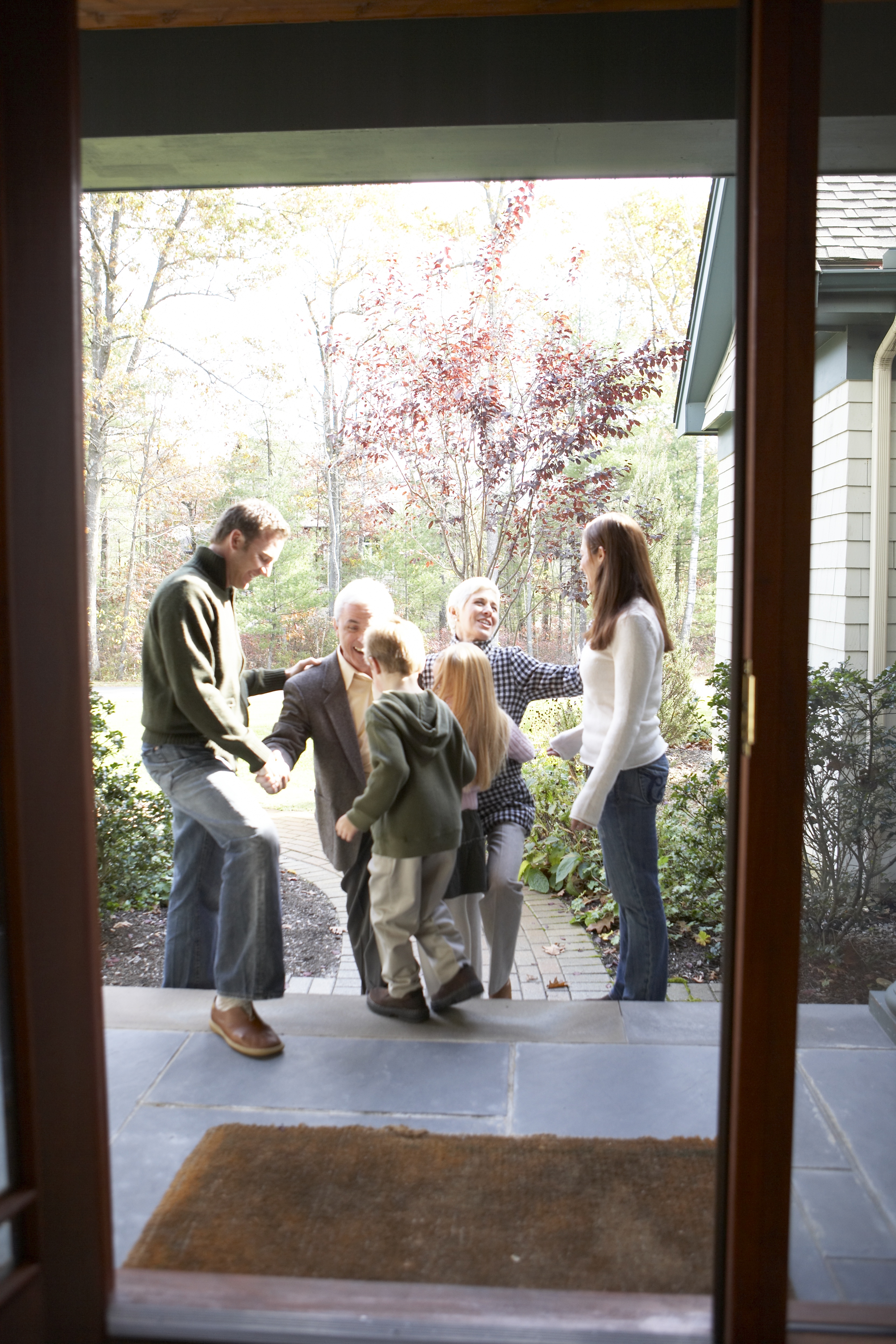 Mid adult couple with children greeting their parents, side view