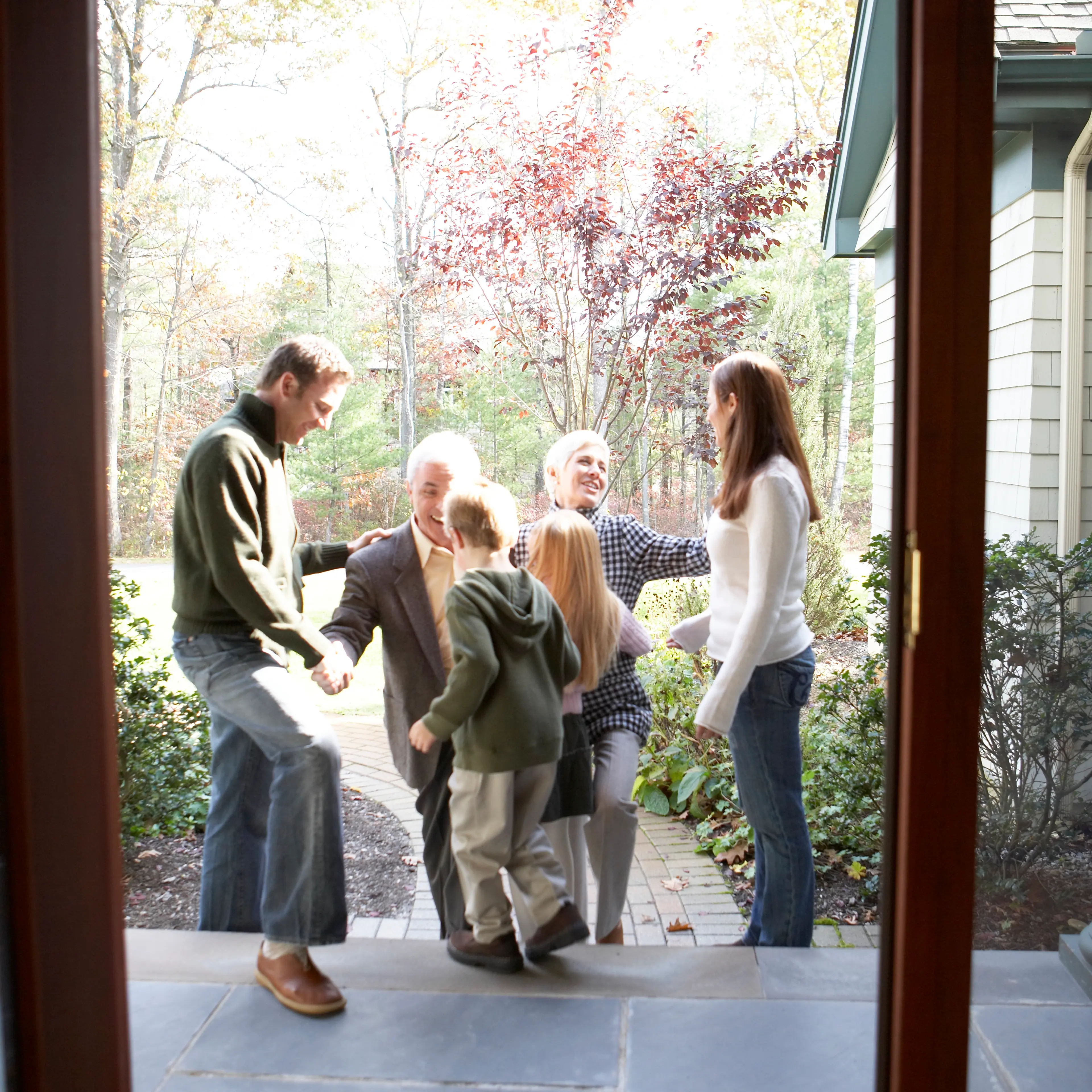 Mid adult couple with children greeting their parents, side view