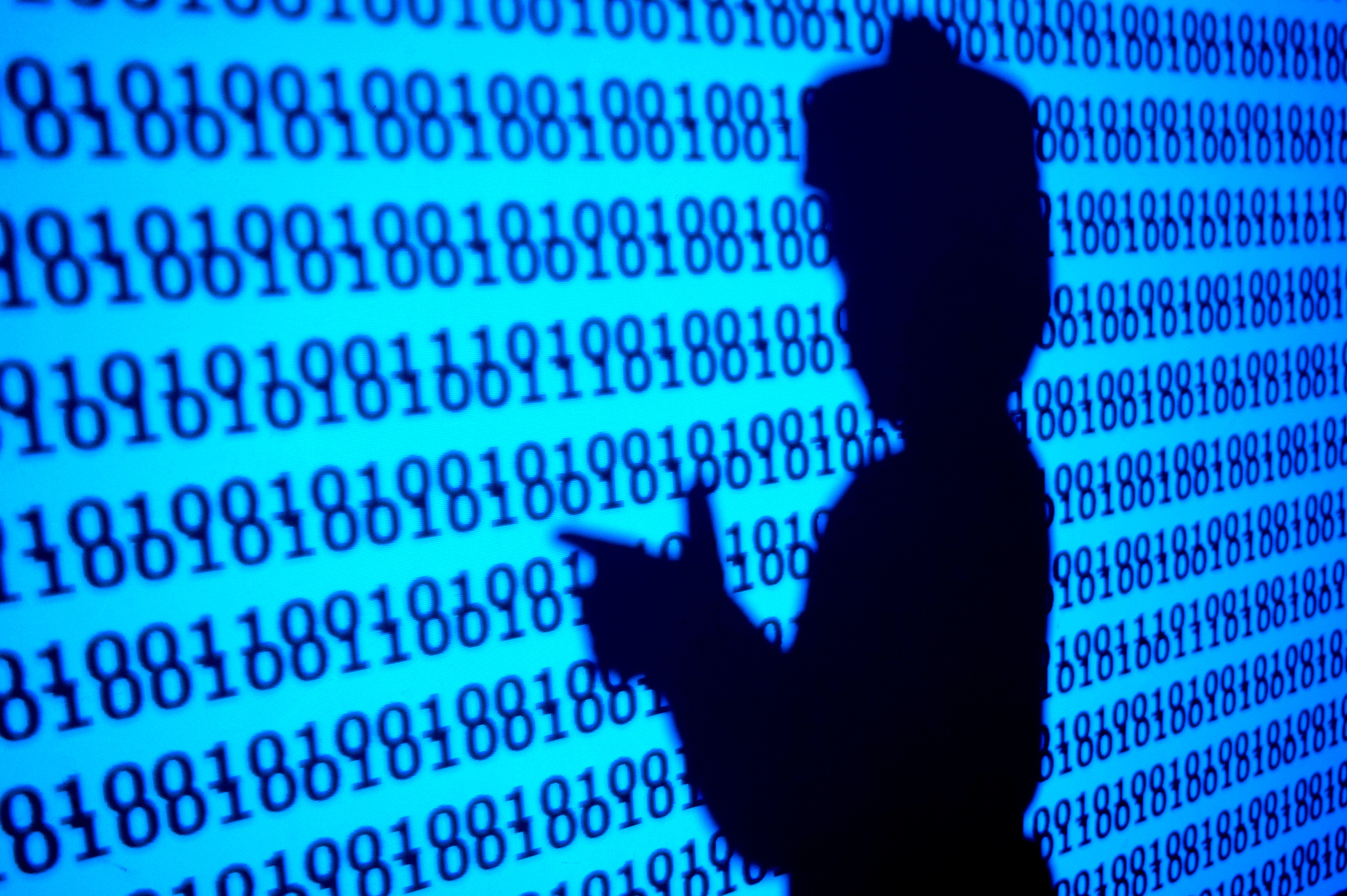Silhouette of a person (child) playing in a virtual world of programs, making the gesture of shooting with his hands.