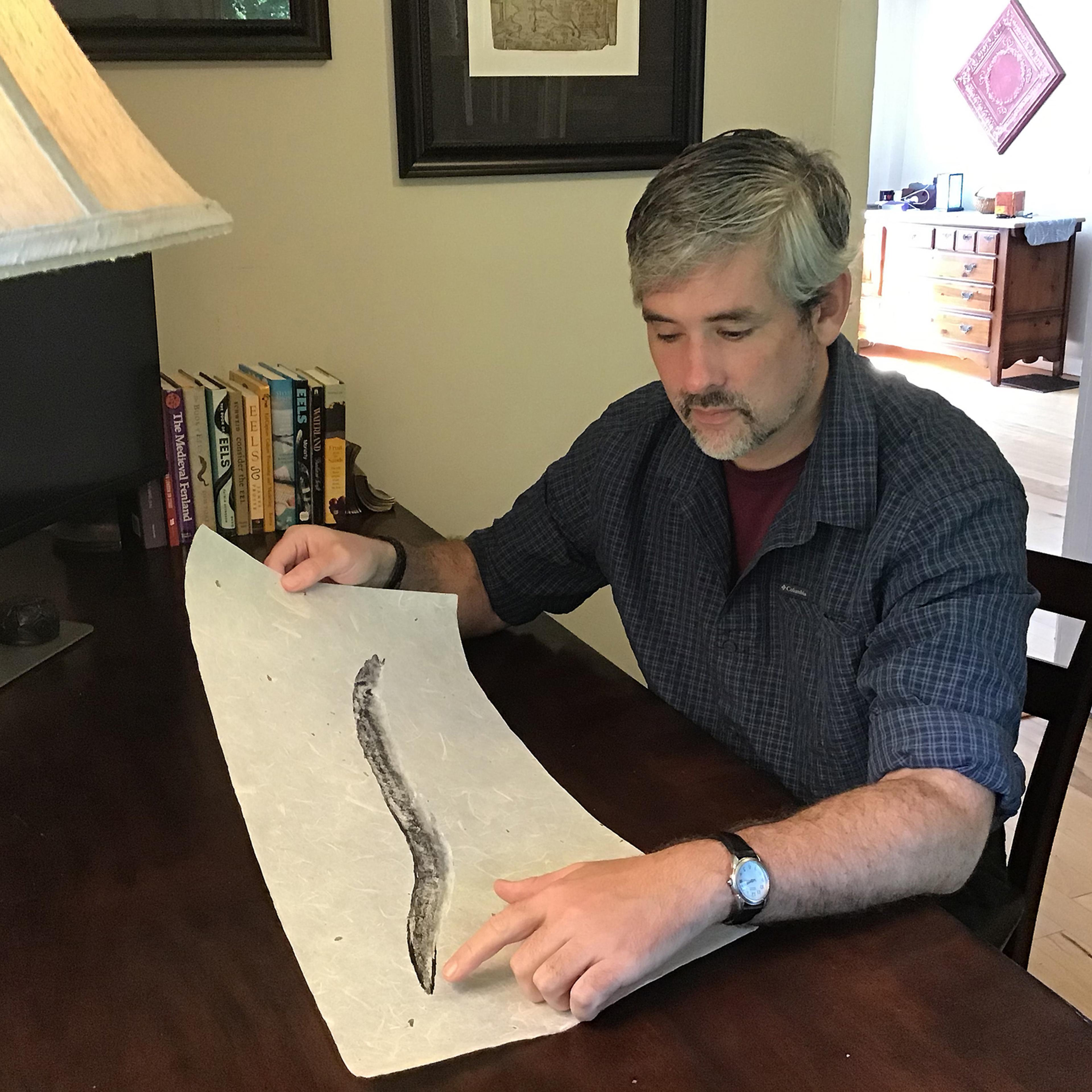 Greenlee looks at a gyotaku print of an eel by Bruce Koike