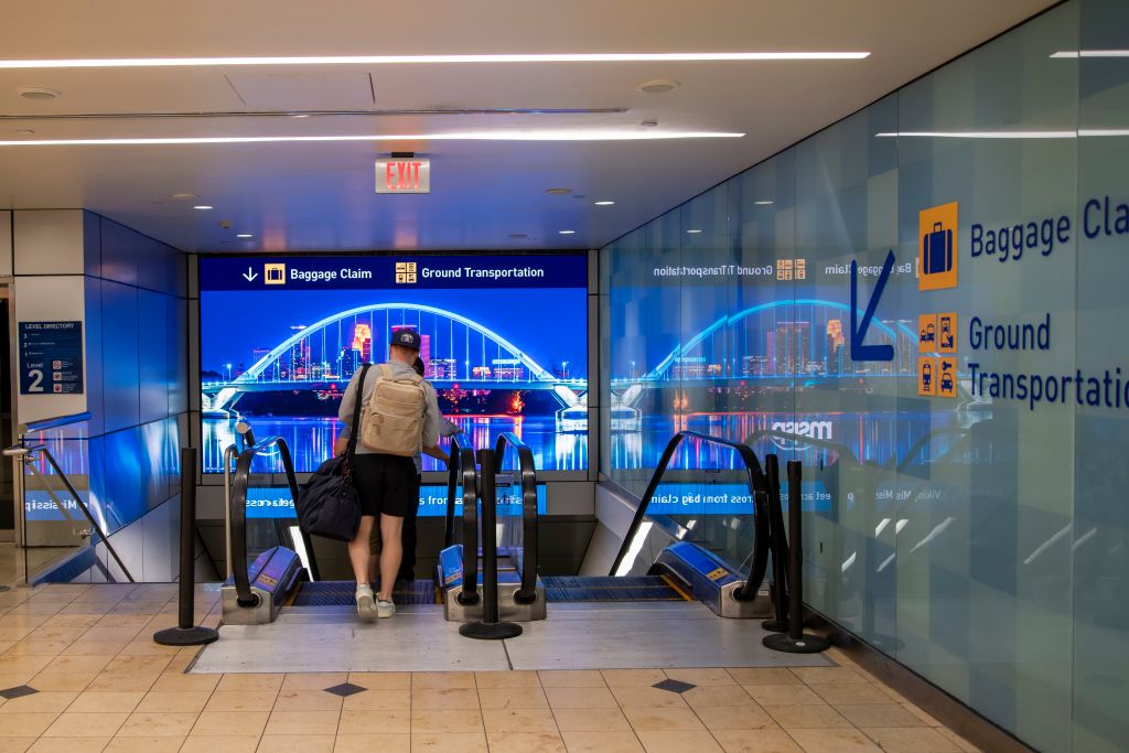 Bloomington, Minnesota. MSP airport. Travelers taking the escalator down to the baggage and ground transportation area.