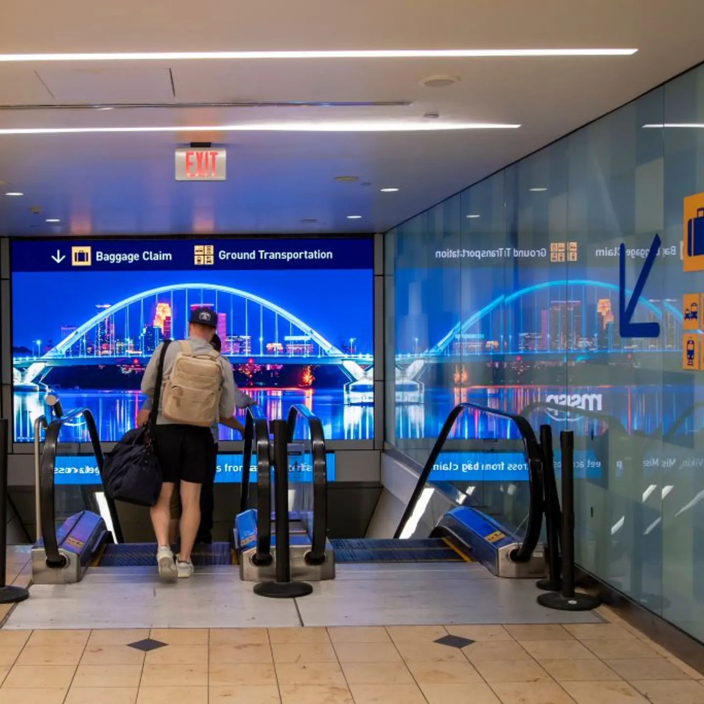 Bloomington, Minnesota. MSP airport. Travelers taking the escalator down to the baggage and ground transportation area.