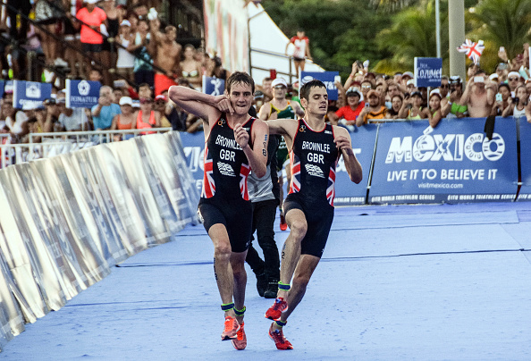 British athlete Alistair Brownlee (L) helps his brother Jonathan Brownlee (R) before crossing the line in second and third place during the ITU World Triathlon Championships 2016 in Cozumel, Quintana Roo, Mexico on September 18, 2016.