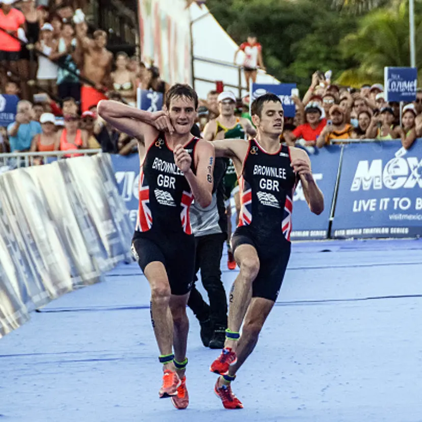 British athlete Alistair Brownlee (L) helps his brother Jonathan Brownlee (R) before crossing the line in second and third place during the ITU World Triathlon Championships 2016 in Cozumel, Quintana Roo, Mexico on September 18, 2016.