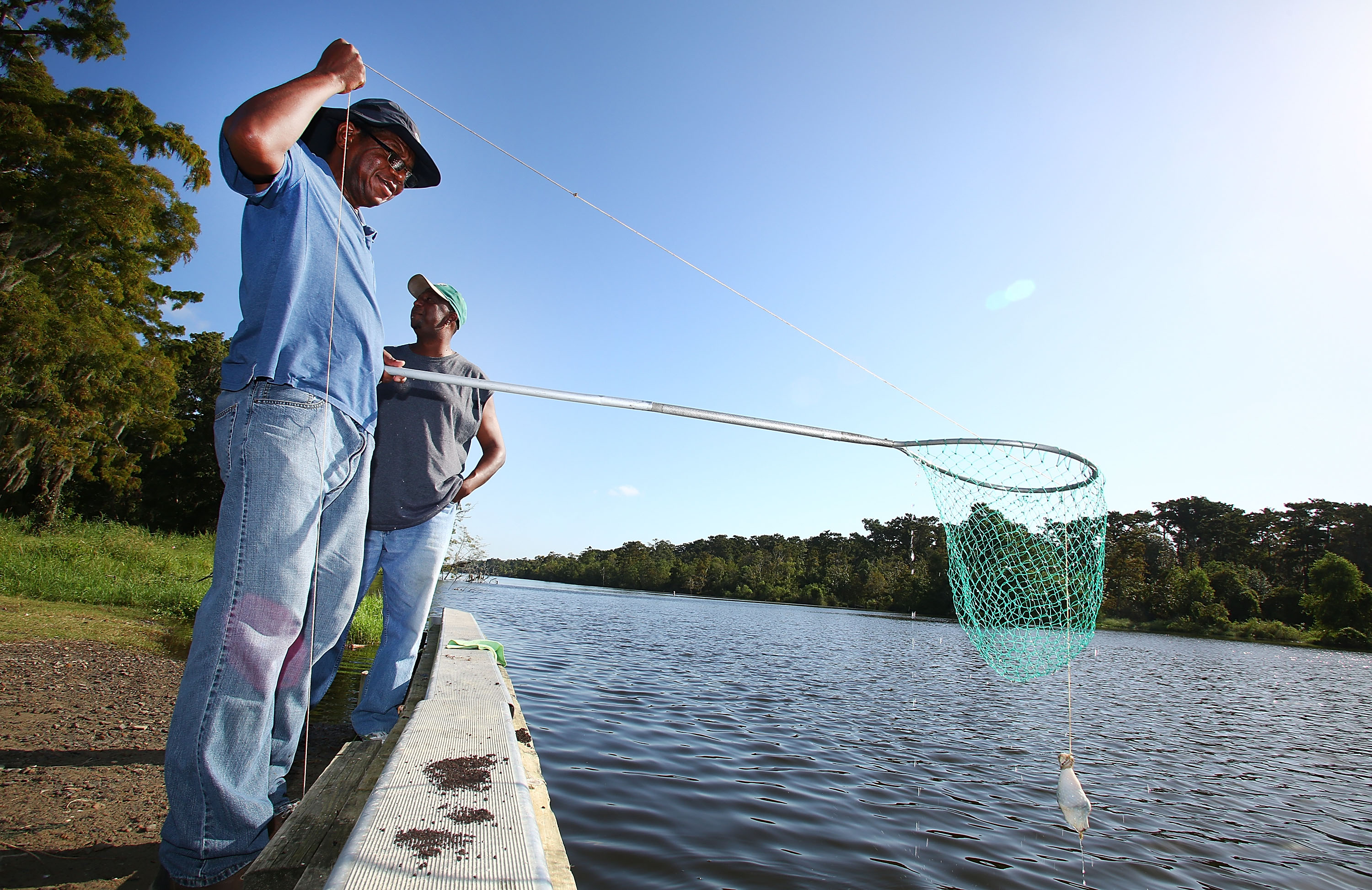 Mike Coleman and Jarad Williams check their crab traps on October 4, 2013 in Grand Isle, Louisiana.