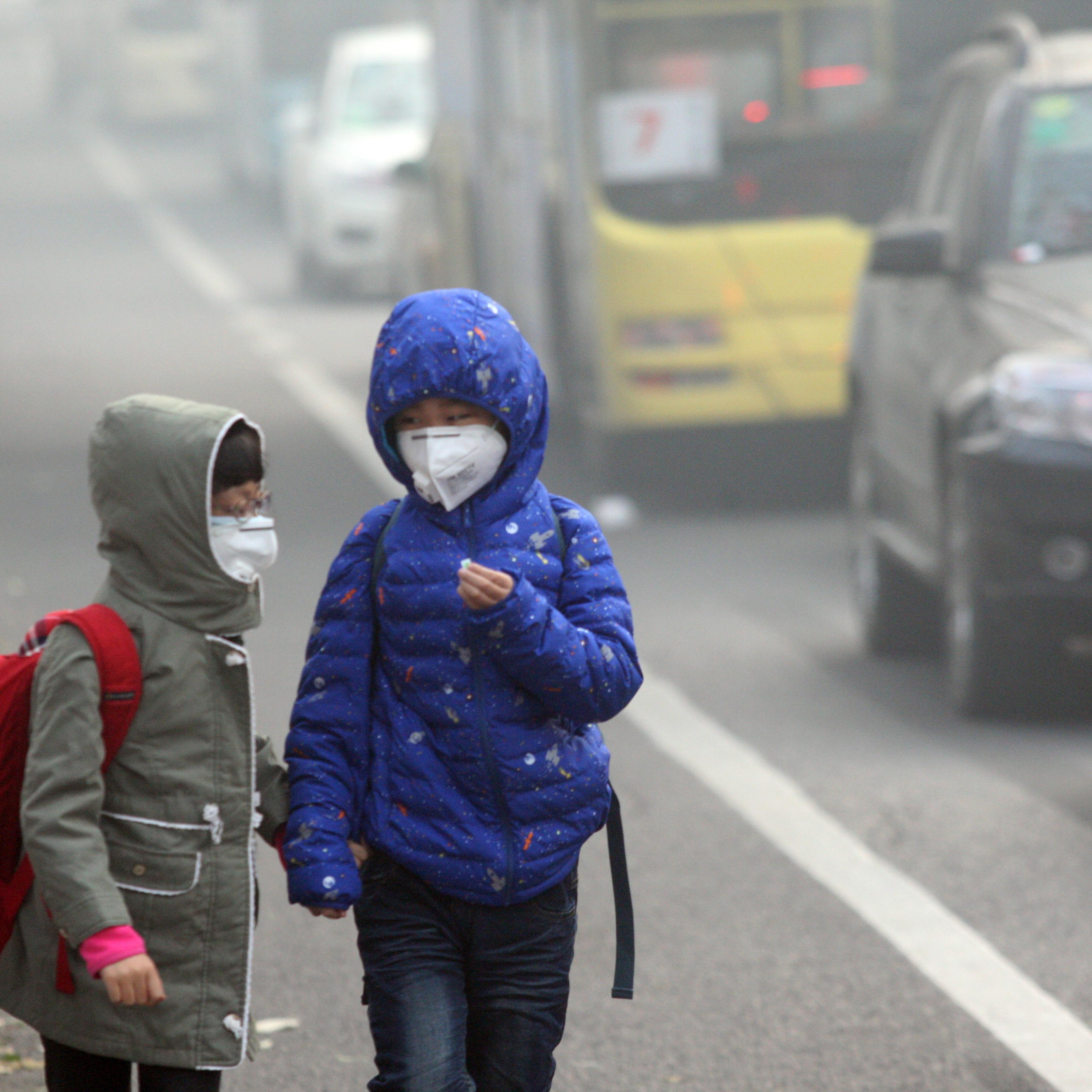 HARBIN, CHINA - NOVEMBER 03: (CHINA OUT) Two children wearing face masks walk in heavy smog on November 3, 2015 in Harbin, Heilongjiang Province of China. Heavy smog stroke northeast China with the visibility in parts of cities reaching less than 50 mete
