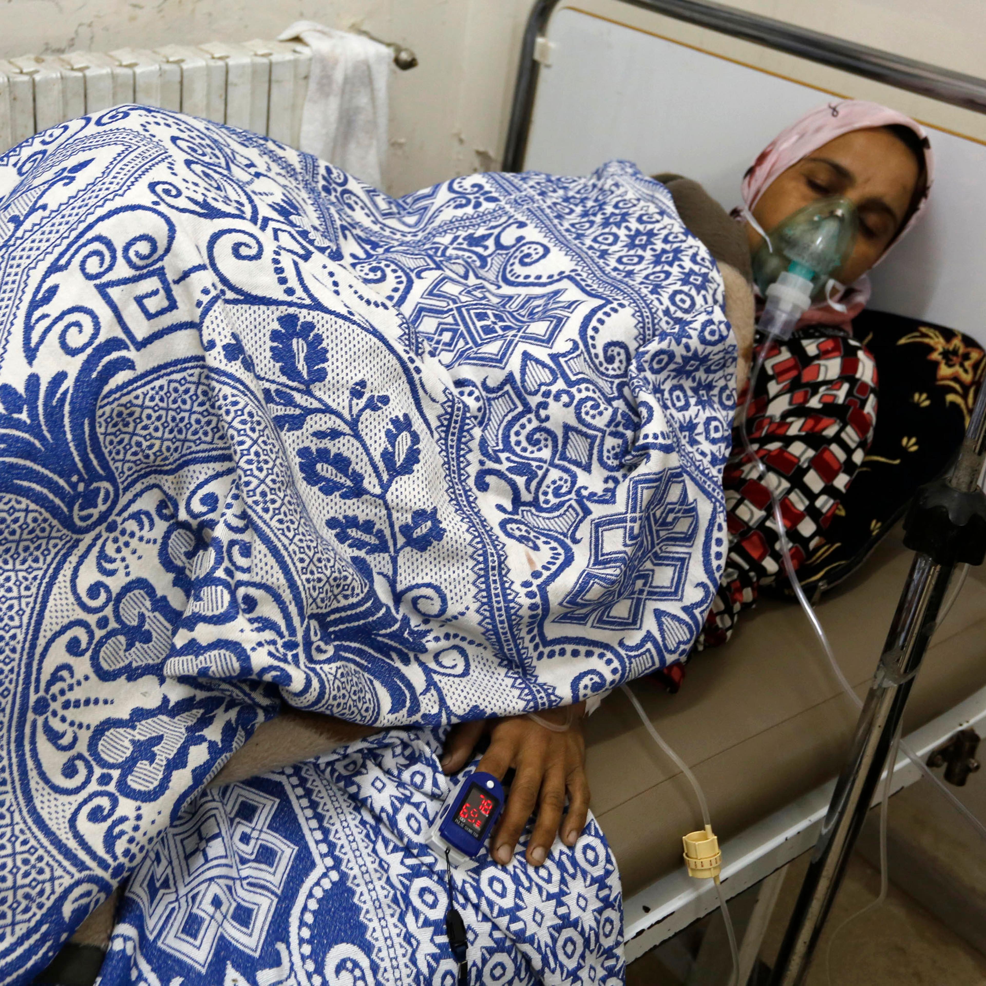 A woman, affected by what activists say was a gas attack, receives treatment inside a makeshift hospital in Kfar Zeita village in Hama