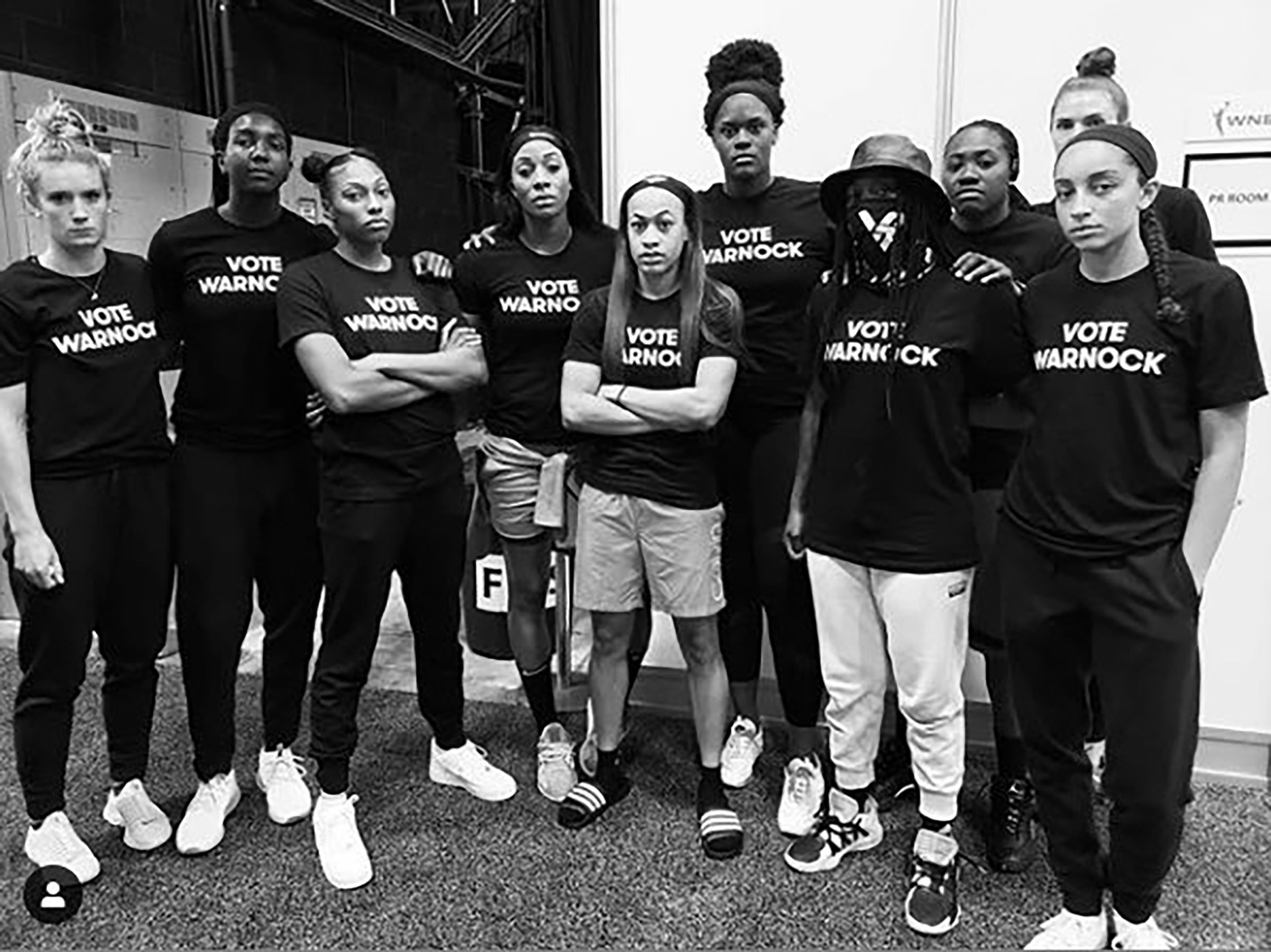 Players of the Atlanta Dream wear t-shirts that read "Vote Warnock"