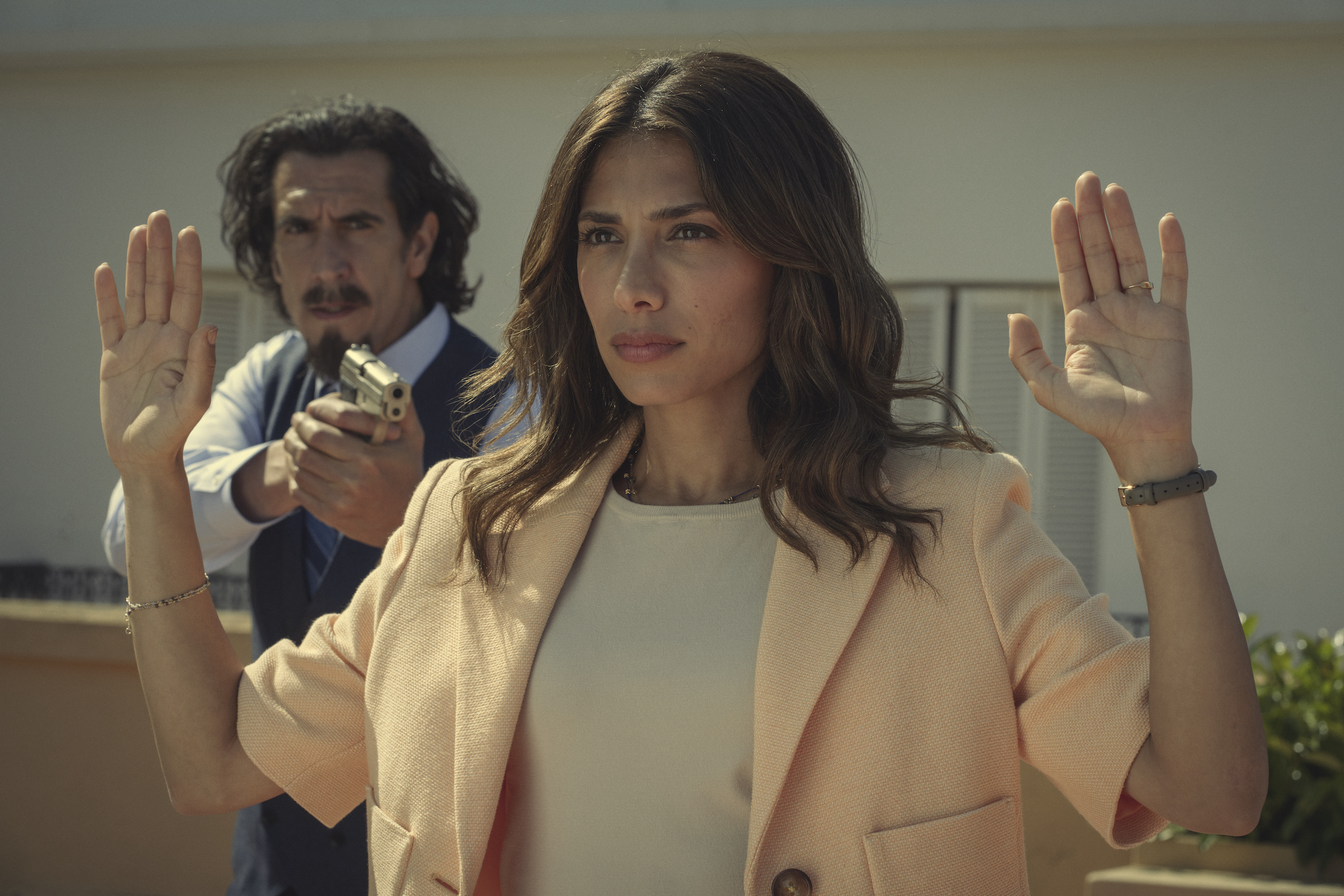 Augustín (Rodrigo Poisón) holds Erin (Evin Ahmad) at gunpoint.
