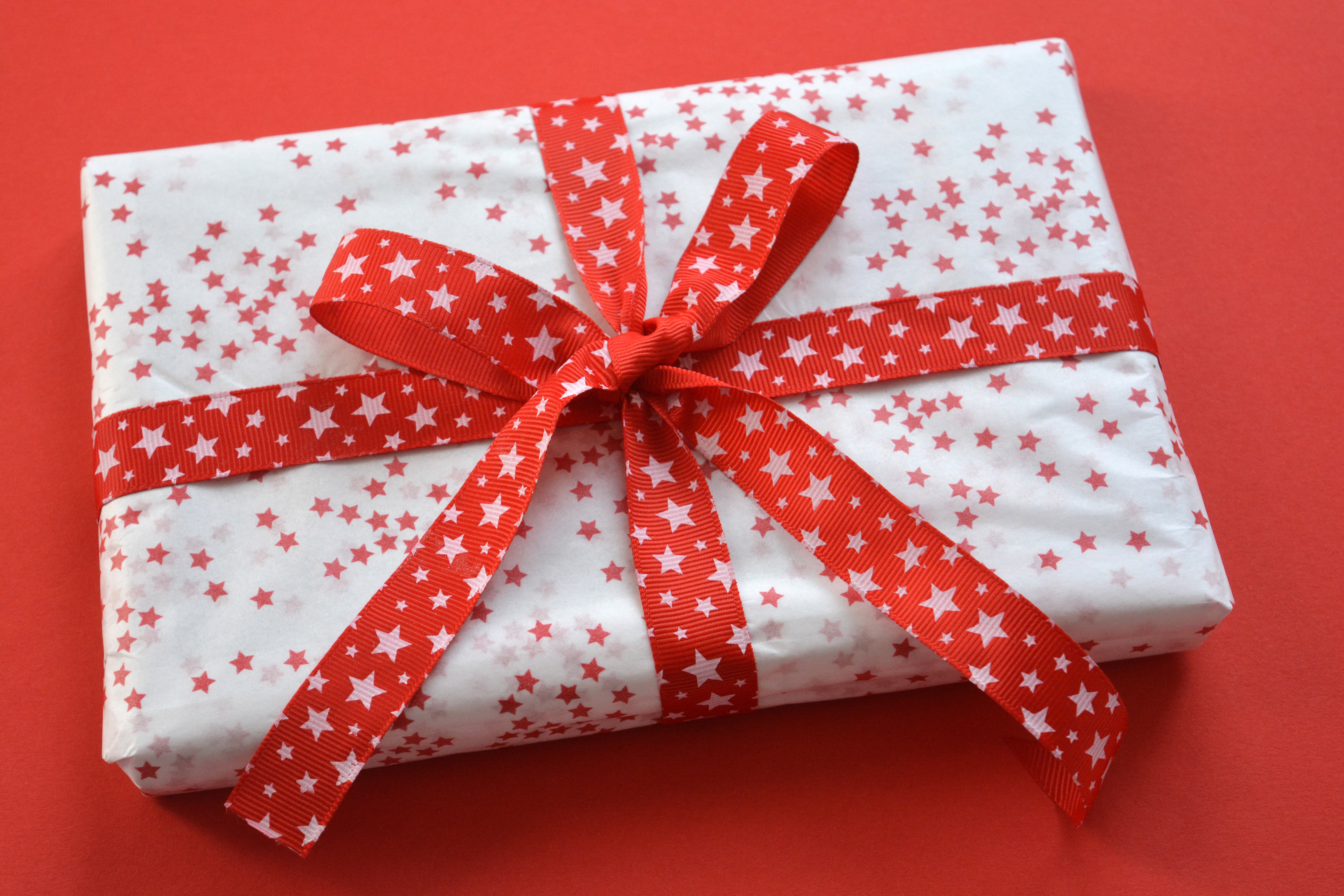High Angle View Of Wrapped Christmas Present On Red Background