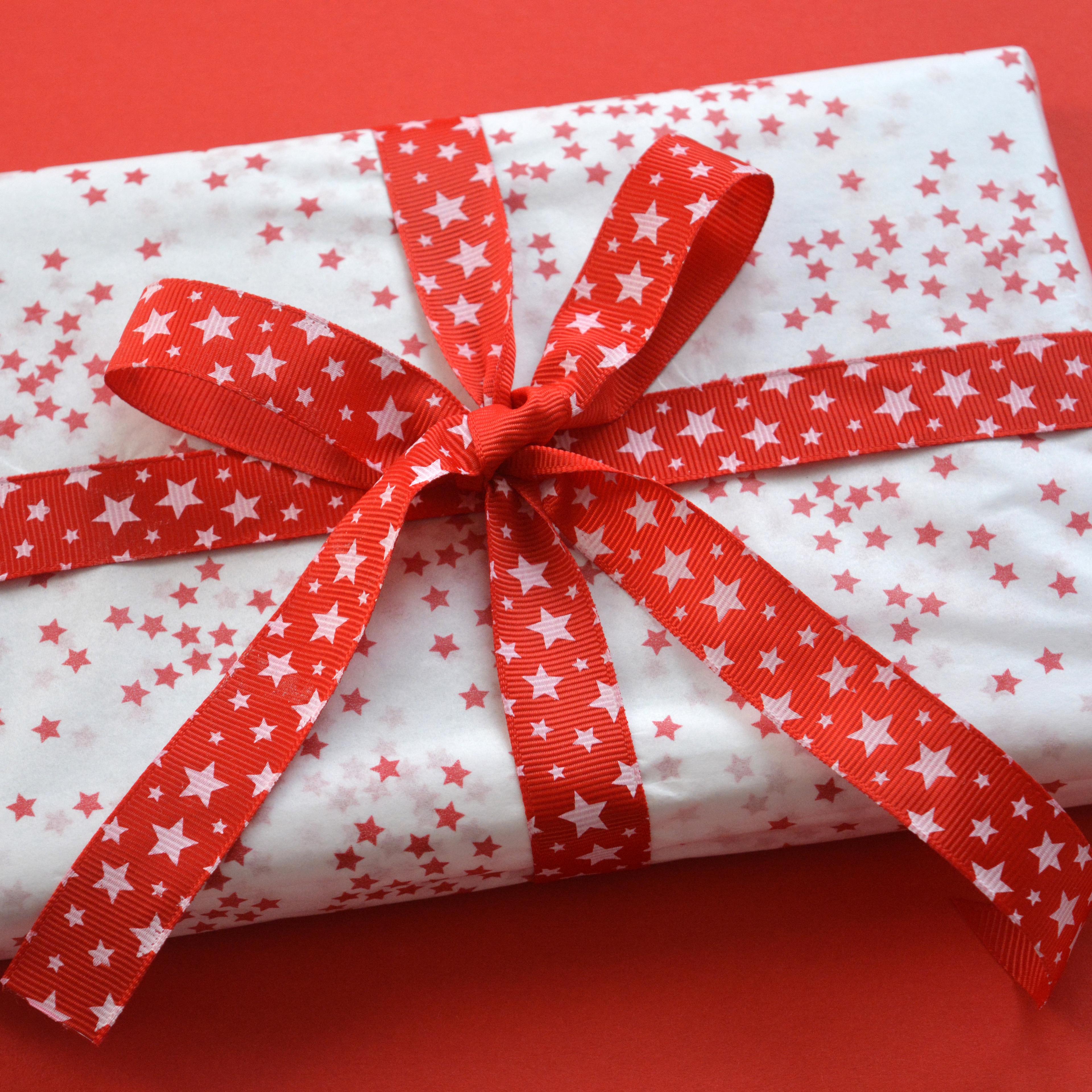 High Angle View Of Wrapped Christmas Present On Red Background