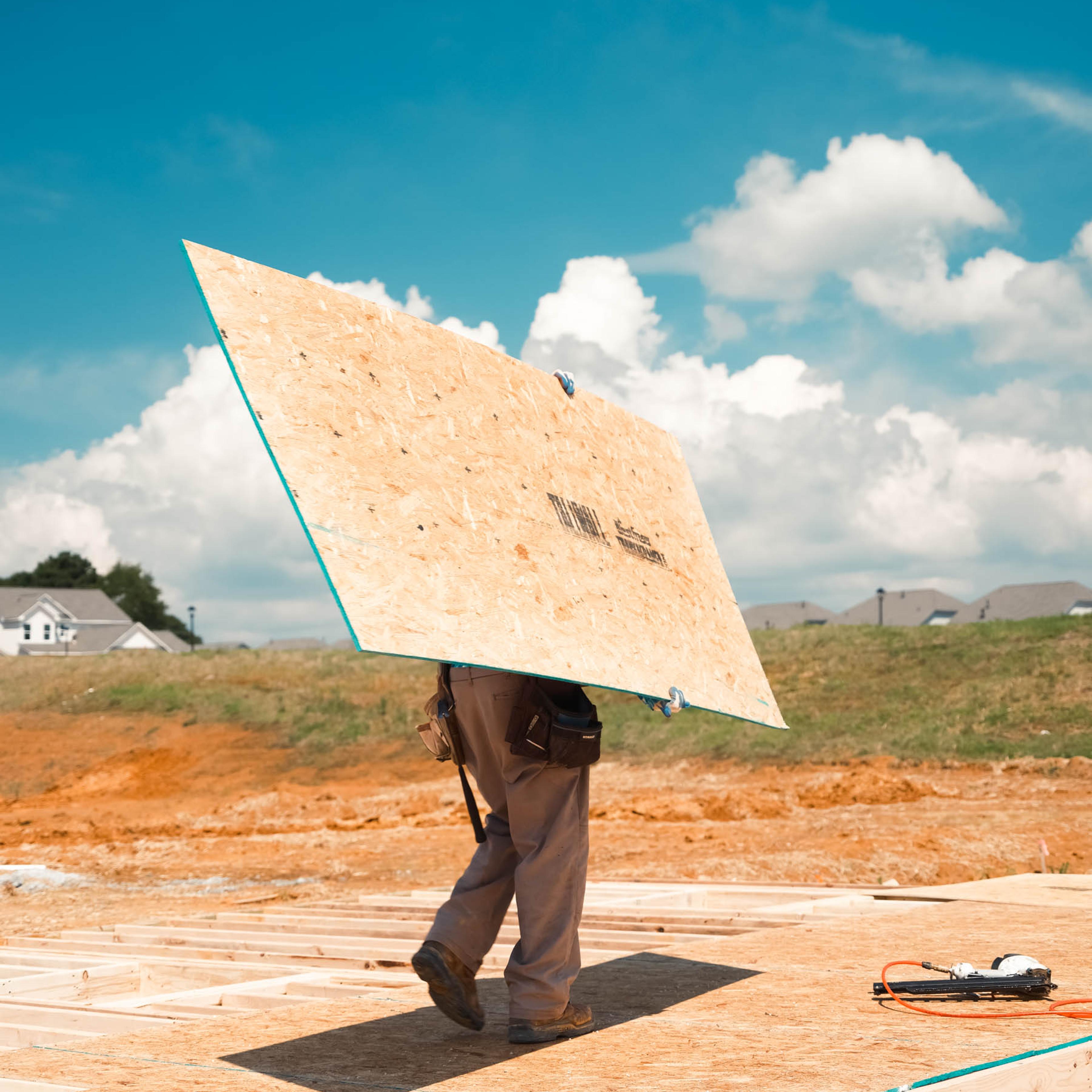 Construction workers toil in the heat working on a new subdivision being built in Loganville, Ga., in July 2023.