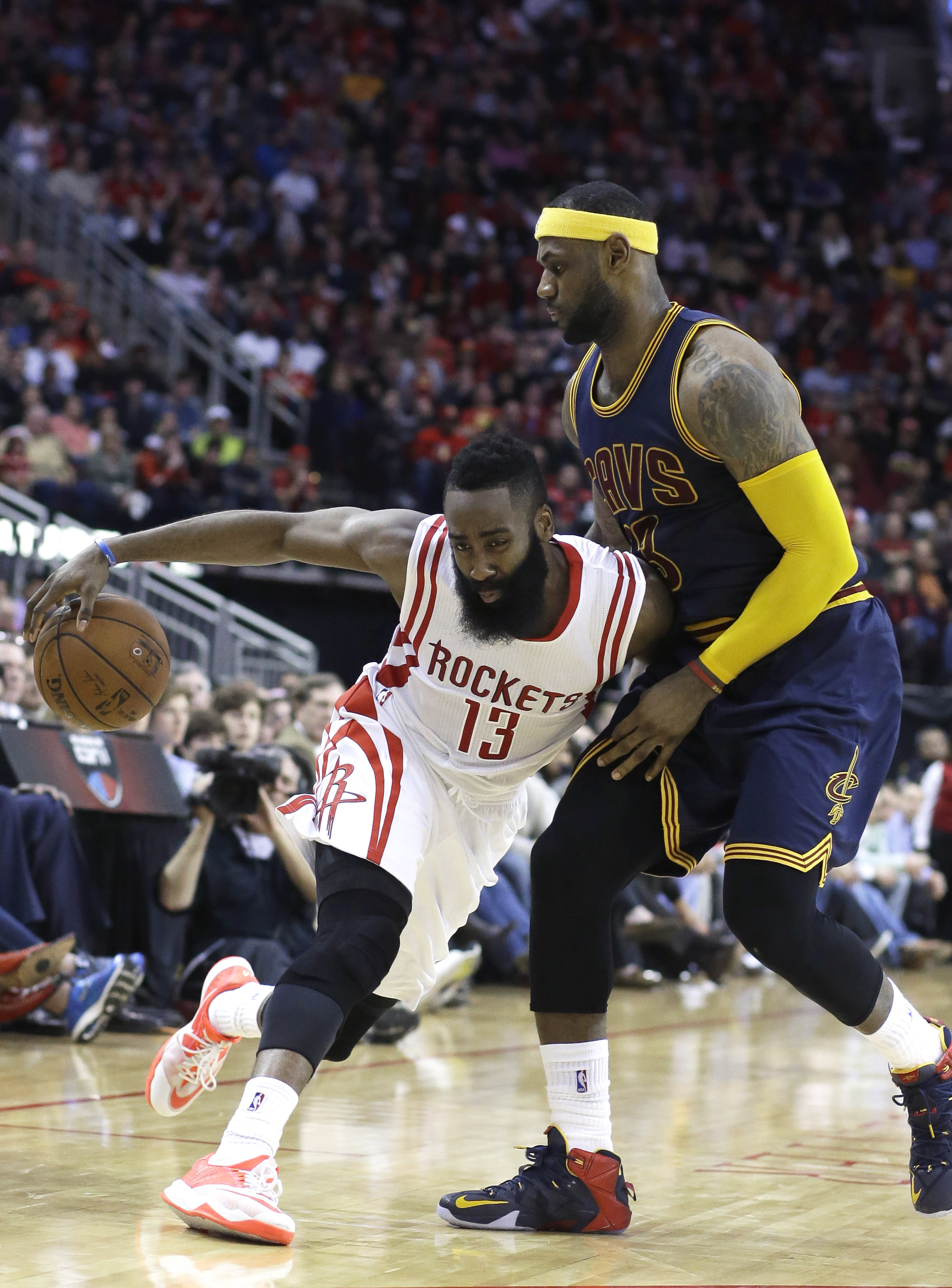 Houston Rockets' James Harden (13) pushes against Cleveland Cavaliers' LeBron James (23) in the second half of an NBA basketball game on March 1, 2015, in Houston.
