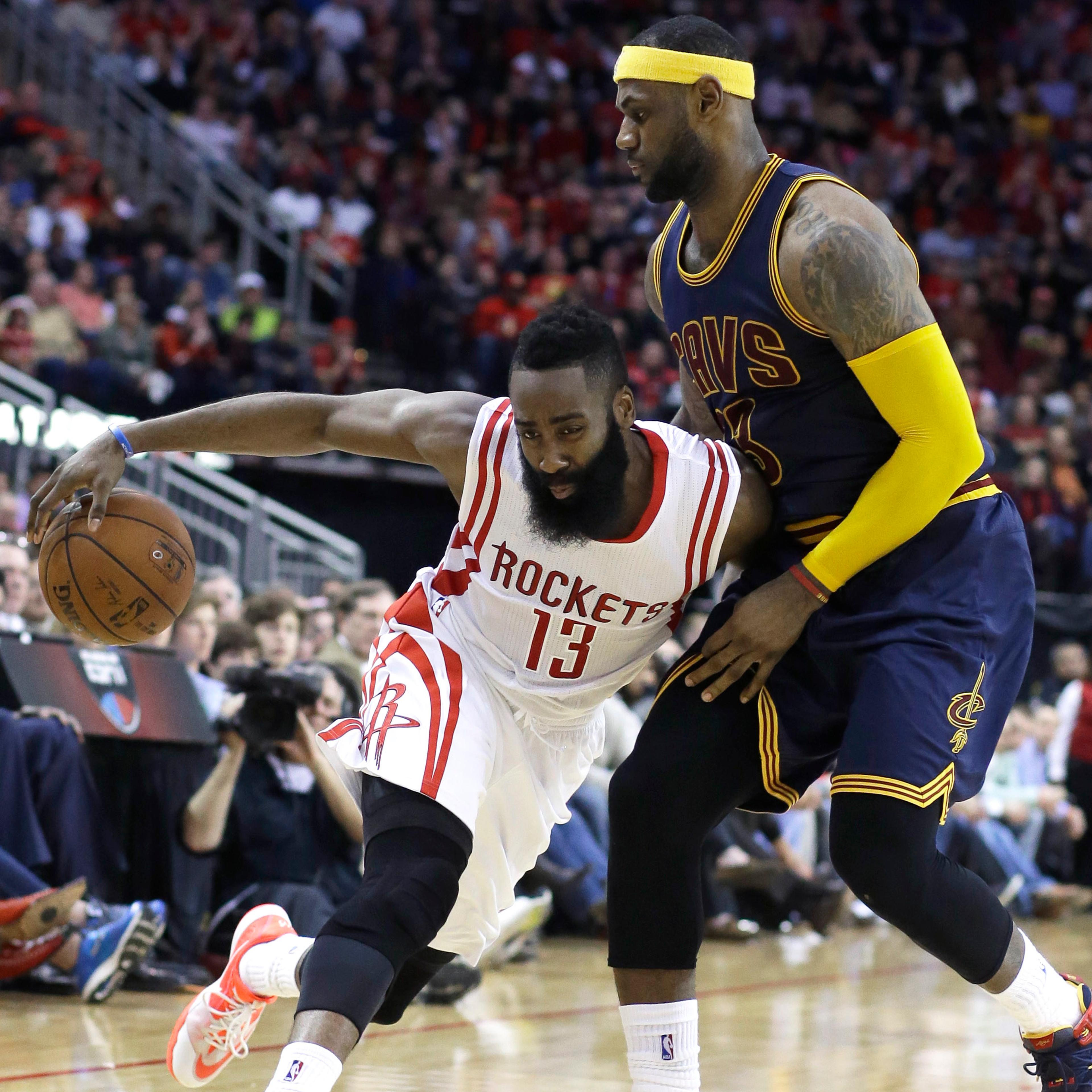 Houston Rockets' James Harden (13) pushes against Cleveland Cavaliers' LeBron James (23) in the second half of an NBA basketball game on March 1, 2015, in Houston.