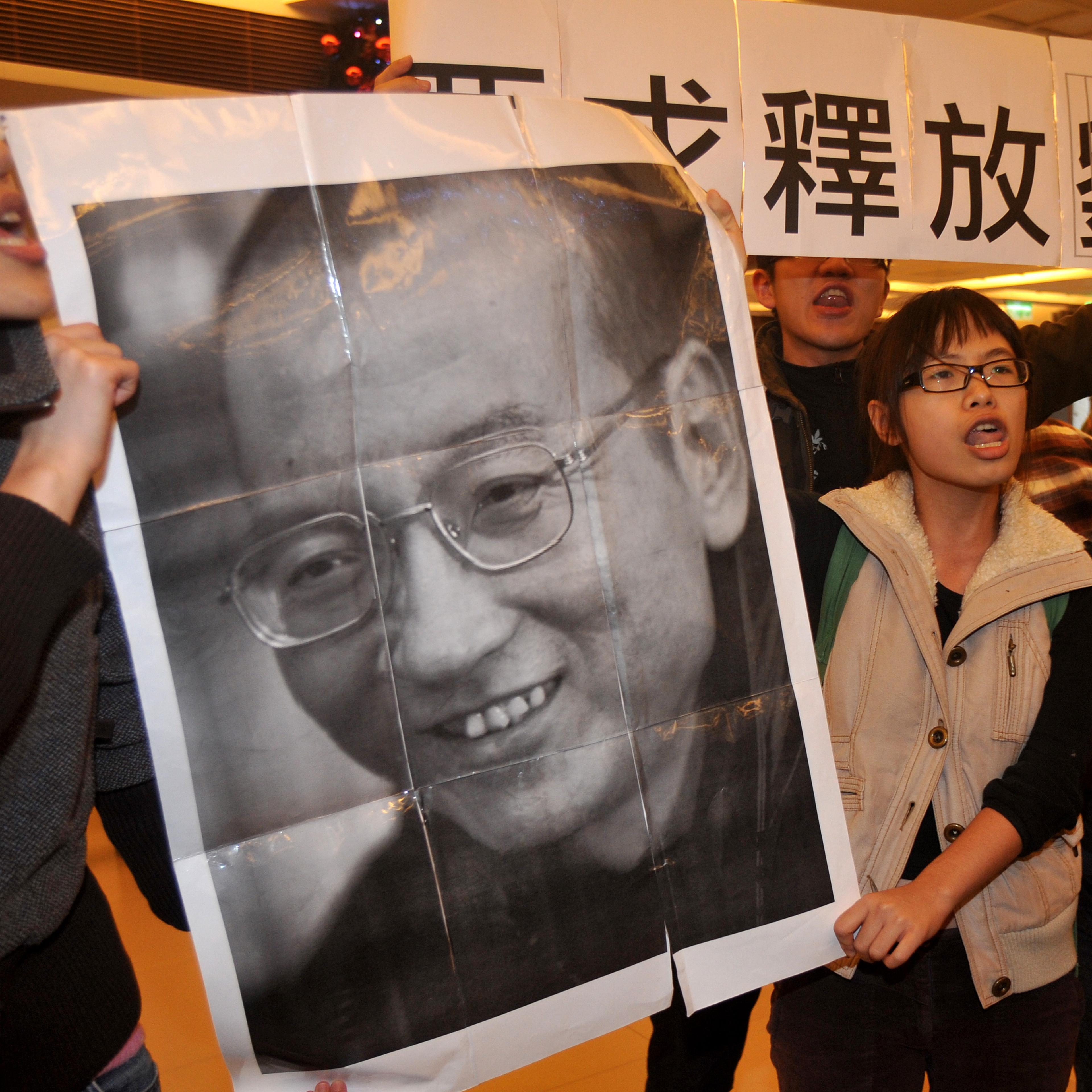 Demonstrators hold a portrait of China's