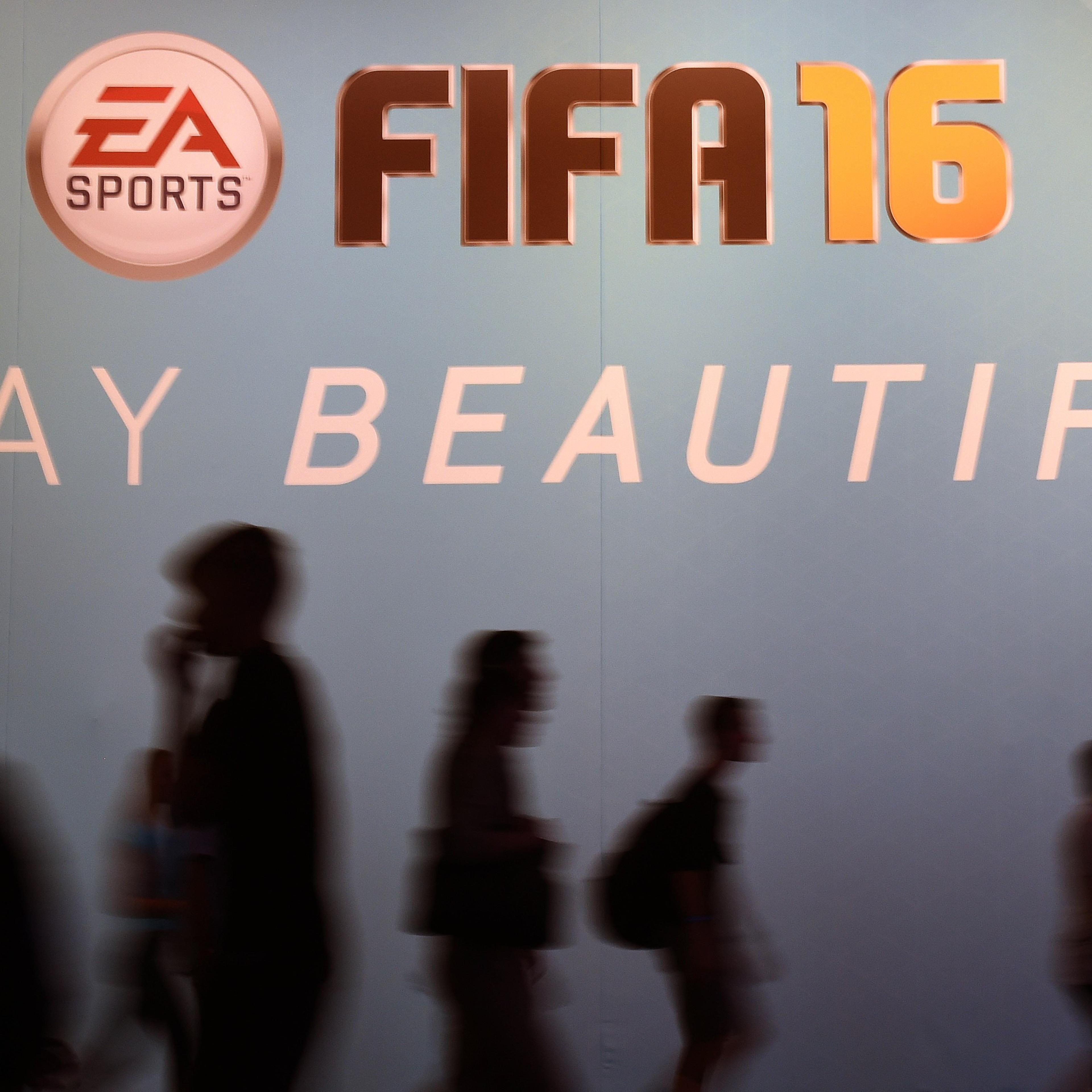 Visitors walk past an ad for the FIFA 16 football game at the Gamescom fair in Cologne, western Germany on August 7, 2015.
