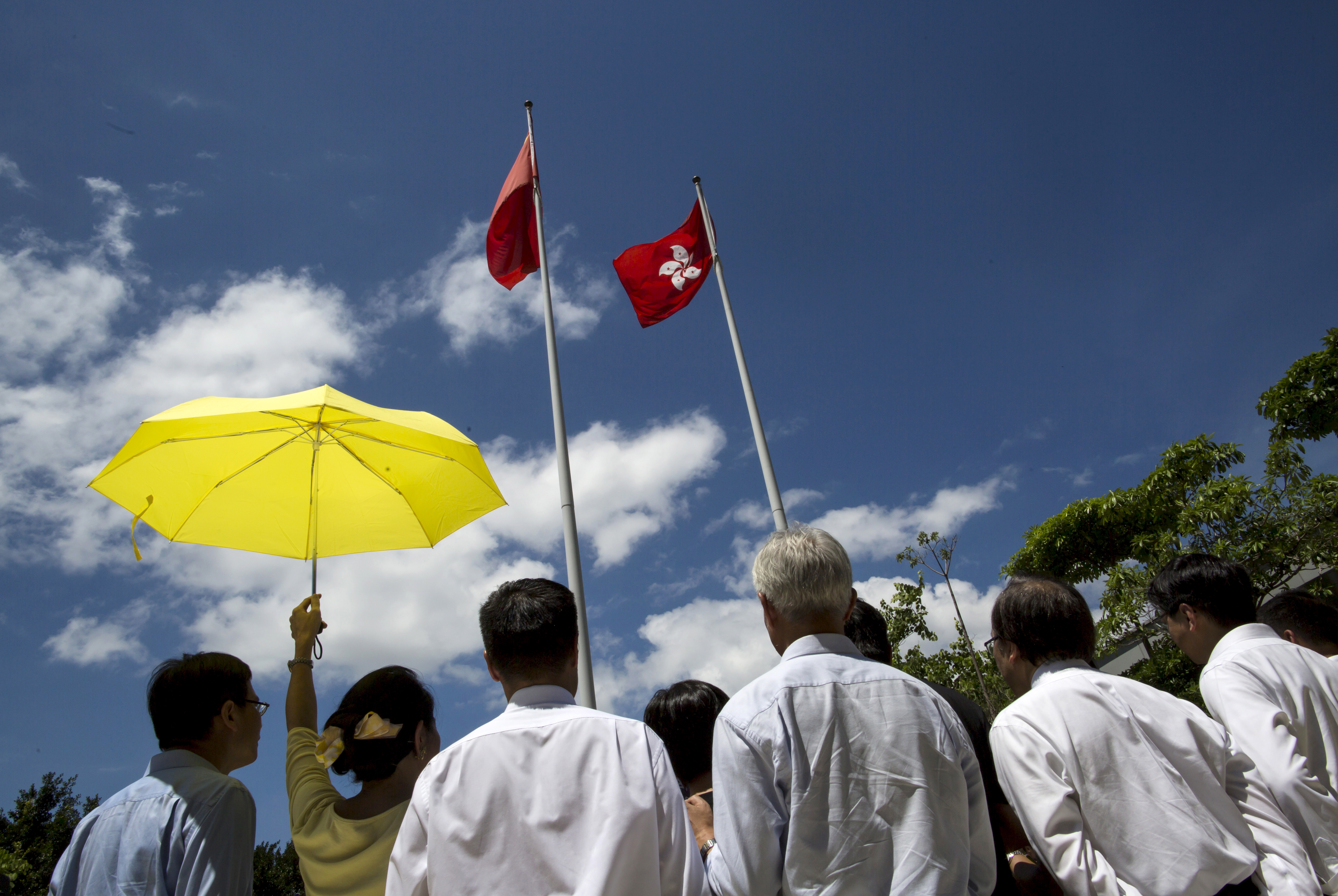 Pro-democracy legislator Claudia Mo holds a yellow umbrella as she speaks outside Legislative Council in Hong Kong