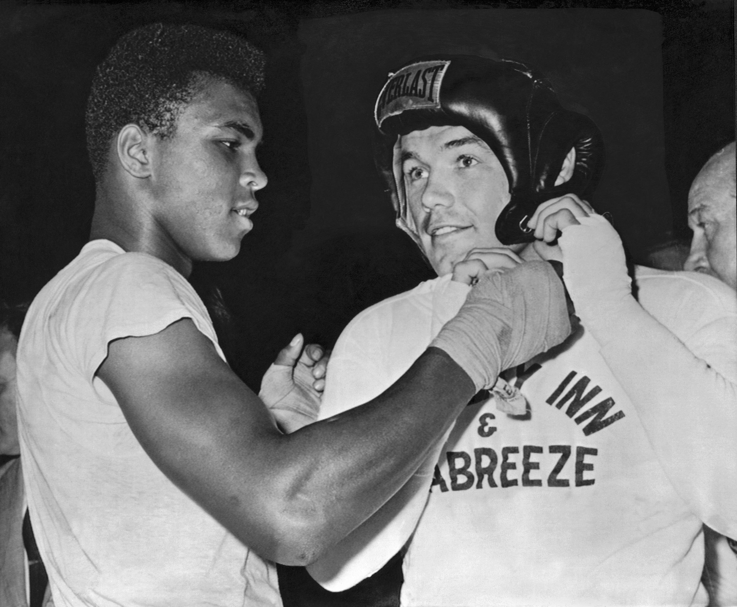 Cassius Clay (Muhammad Ali) gives an assist to heavyweight challenger Ingemar Johansson before going a couple of rounds as his sparring partner for Johansson's upcoming title fight with Floyd Patterson, Catskills, New York, 1961.