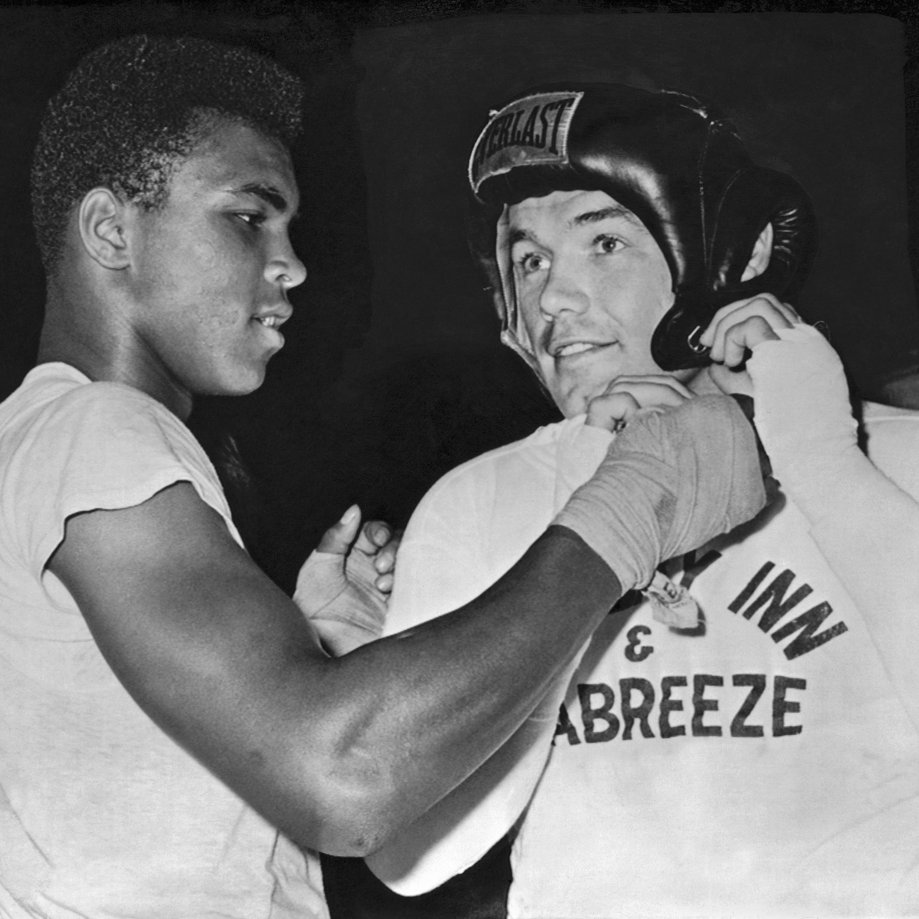 Cassius Clay (Muhammad Ali) gives an assist to heavyweight challenger Ingemar Johansson before going a couple of rounds as his sparring partner for Johansson's upcoming title fight with Floyd Patterson, Catskills, New York, 1961.