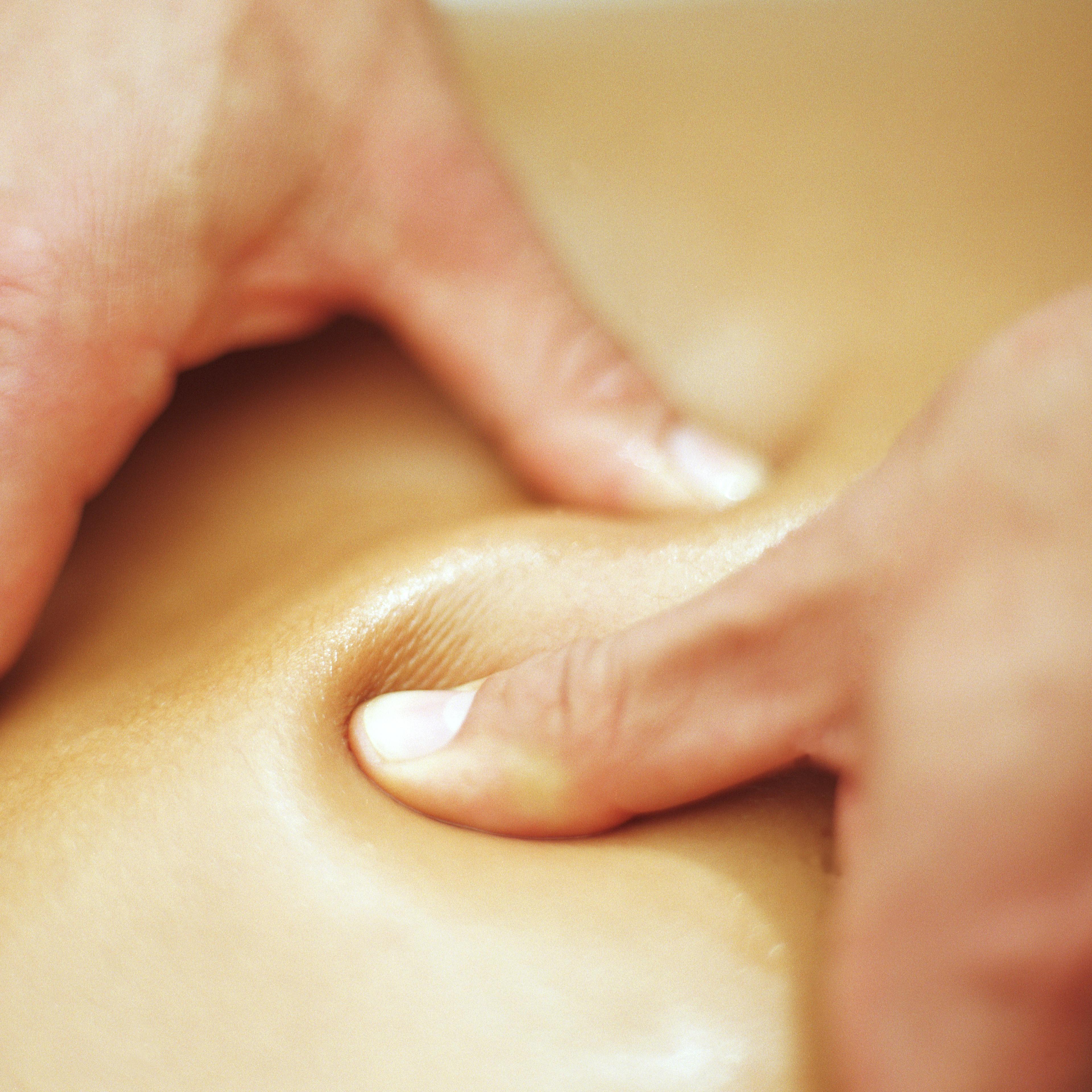 Man massaging woman, pressing thumbs into skin, close-up