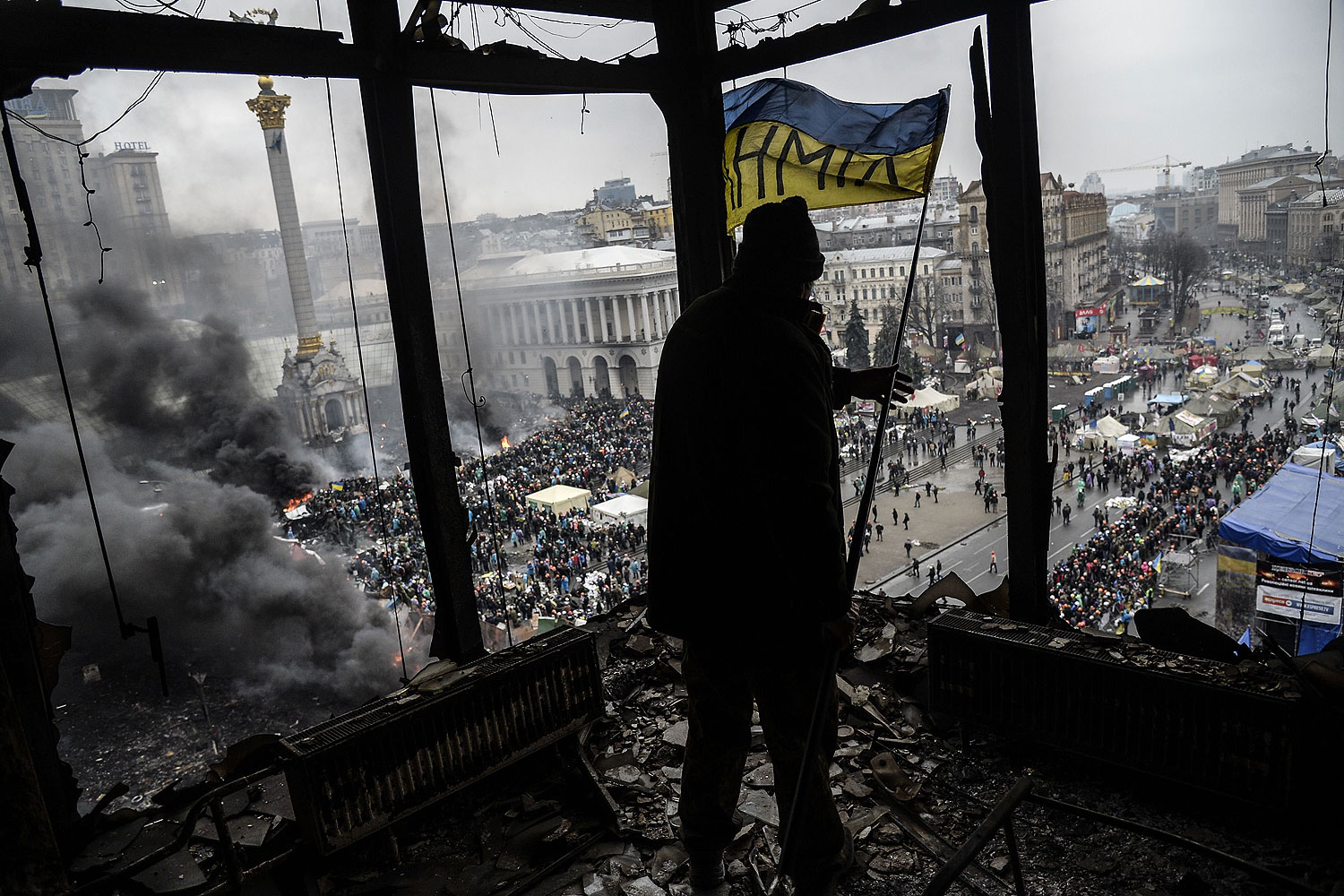 A demonstrator stands on a balcony overlooking Independence square in Kiev, Feb. 20, 2014
