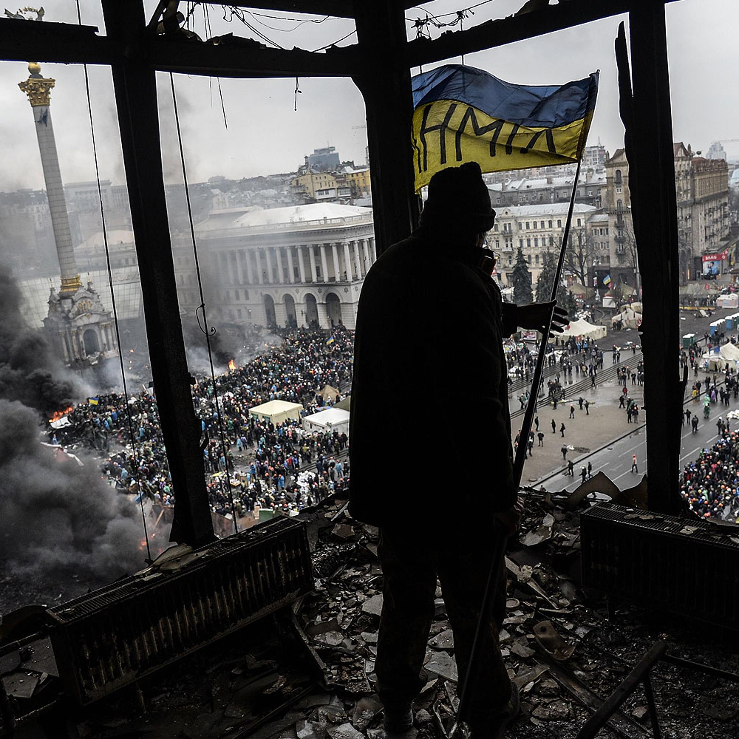 A demonstrator stands on a balcony overlooking Independence square in Kiev, Feb. 20, 2014