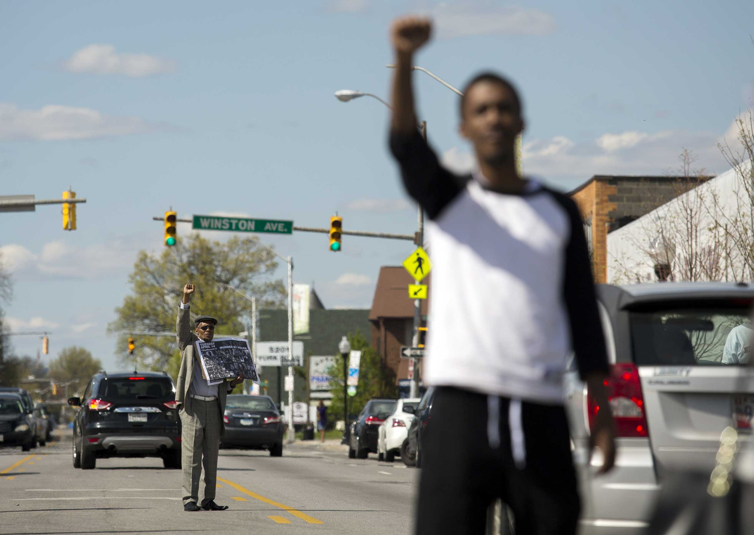 Protestors encourage passing cars to honk while standing in the middle of York Road near Vaughn Greene Funeral Services during the wake of Freddie Gray in Baltimore on April 26, 2015.