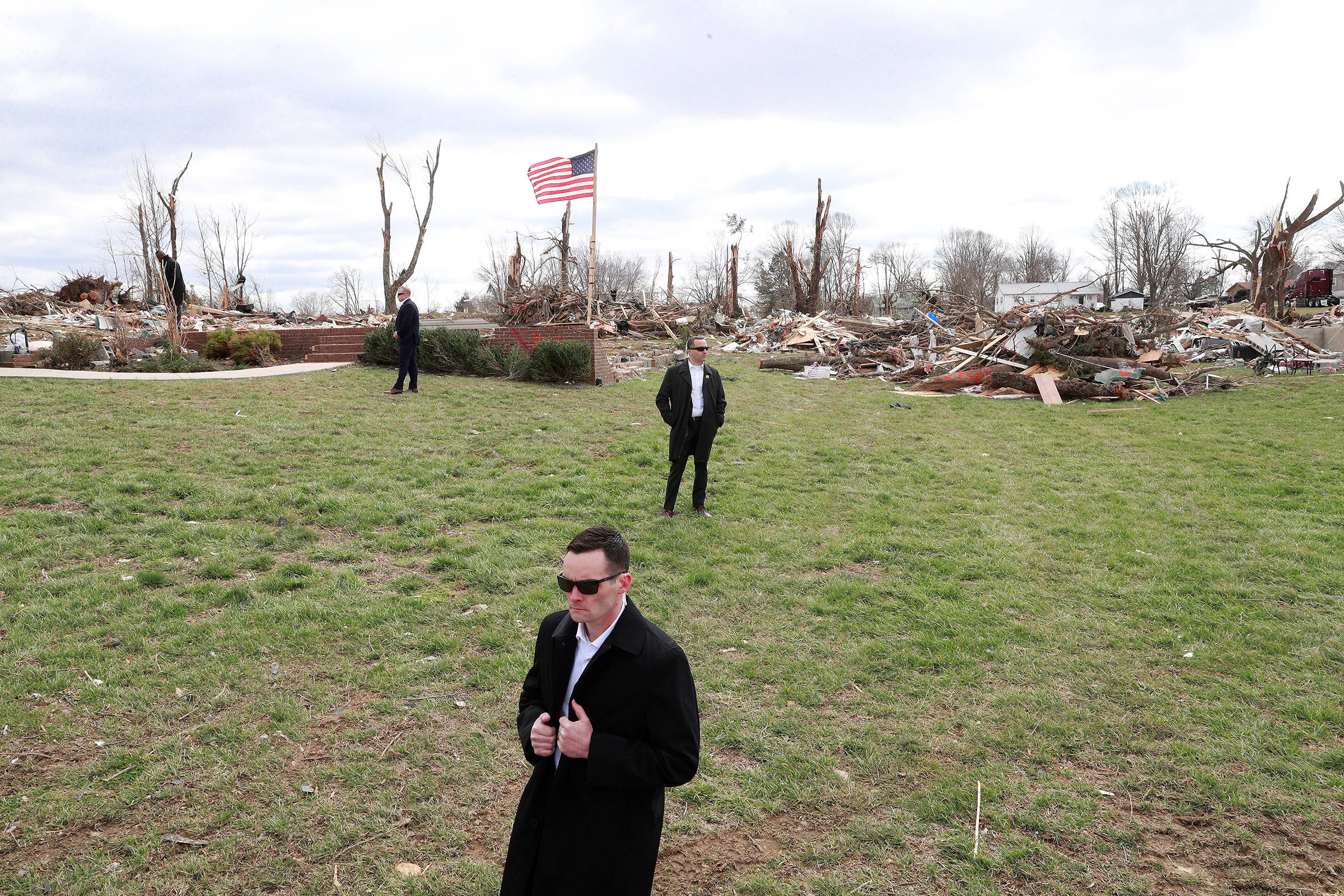 U.S. Secret Service agents stand by as President Trump, not pictured, observes tornado damage in Cookeville, east of Nashville, on March 6, 2020.
