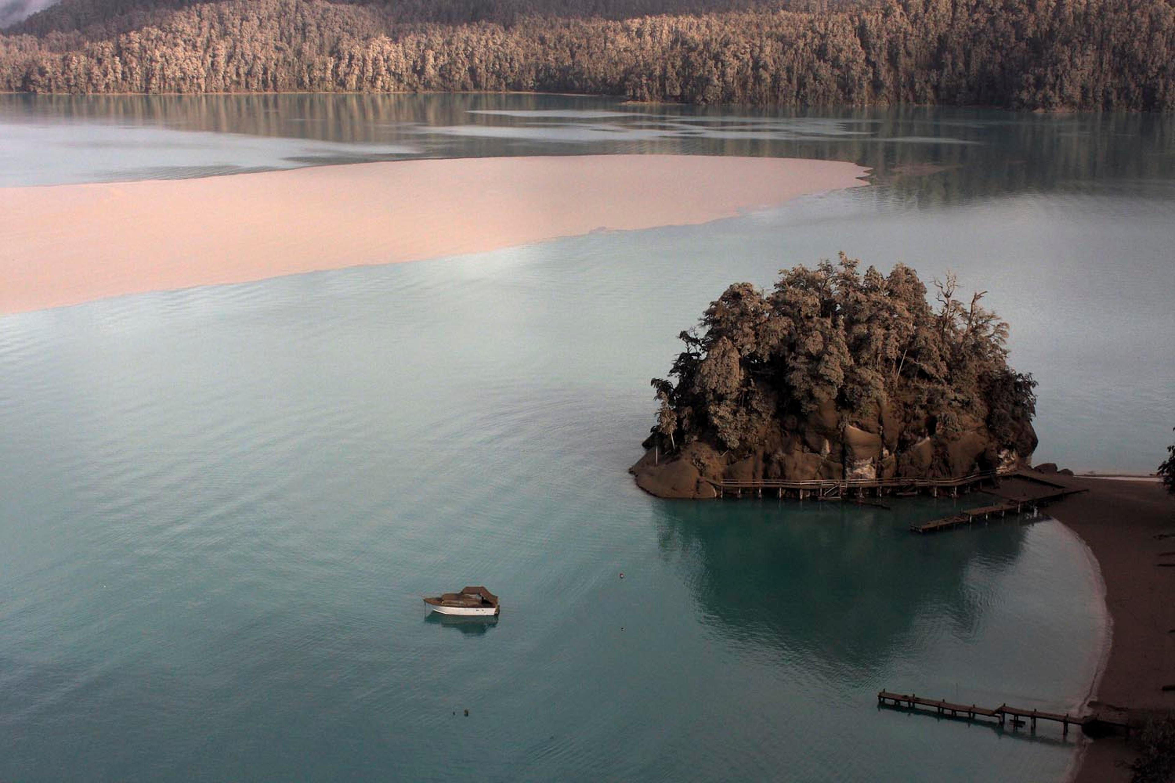 A boat moored in Puerto Arauco, at the Nahuel Huapi Lake and the landscape around are seen covered with sand and volcanic from the Chilean Puyehue-Cordon Caulle volcano in Villa La Angostura, southern Argentina, Friday, June 17, 2011.