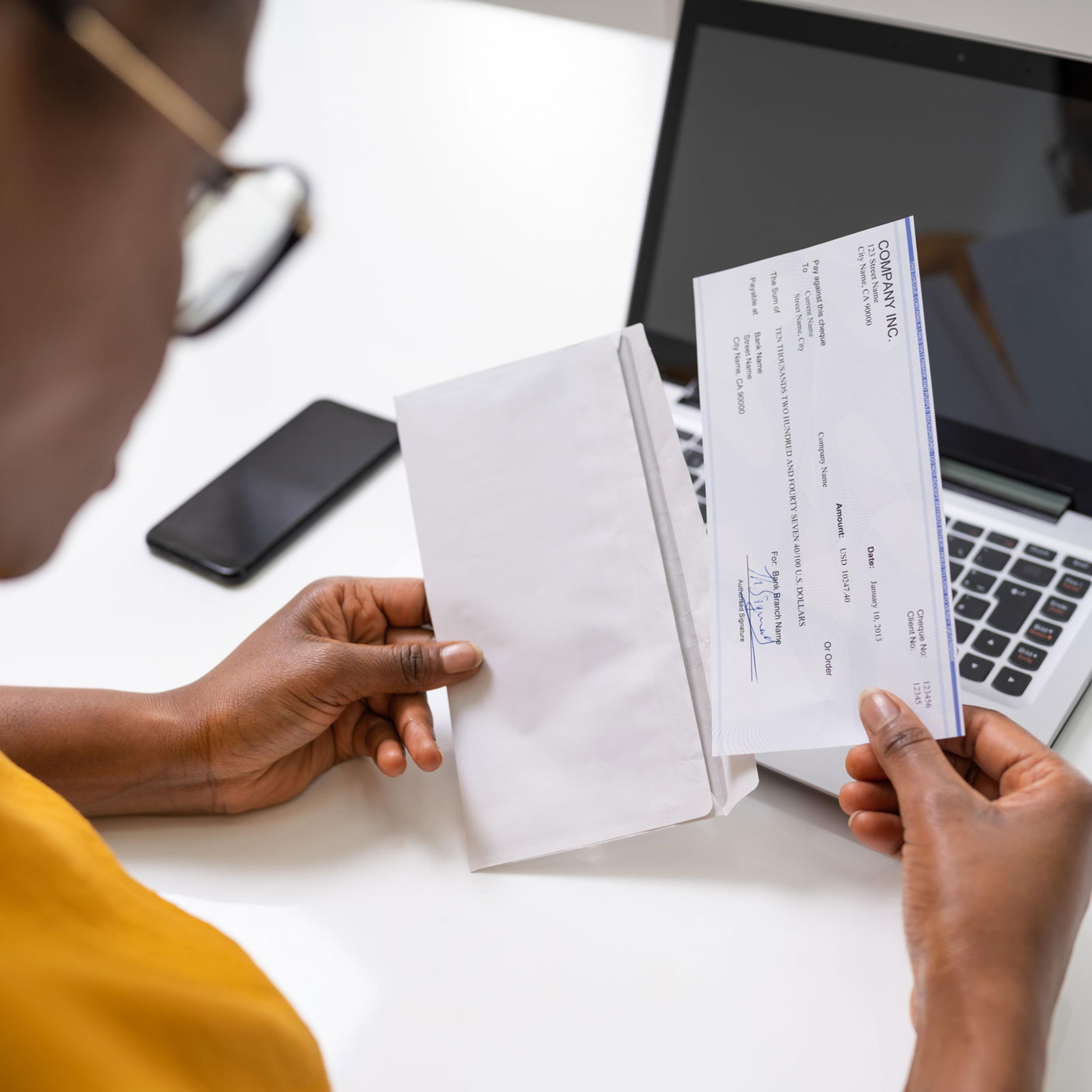 African-American woman holding paycheck