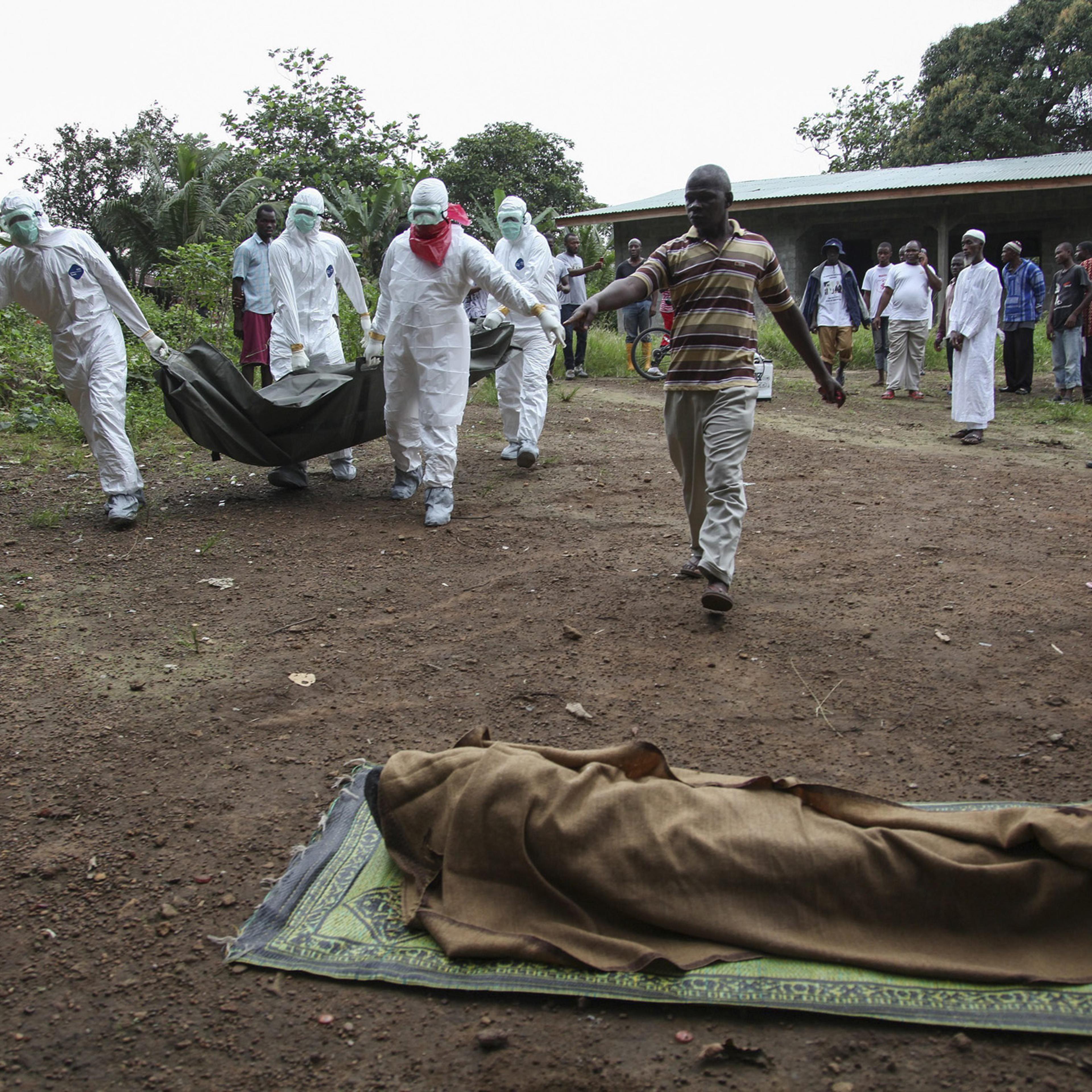 Liberian nurses carry the body of an Ebola victim on the way to bury them in the Banjor Community on the outskirts of Monrovia, Liberia, Aug. 6, 2014.