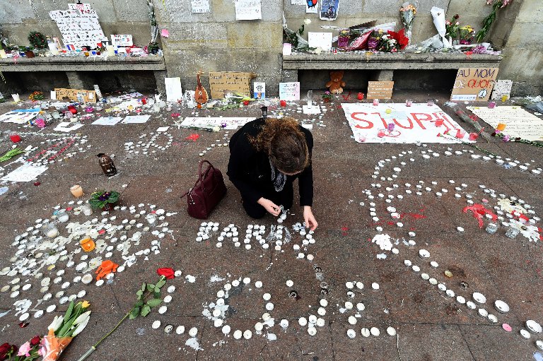 A woman lights candles during a minute of silence on Nov. 16, 2015 on the Place du Capitole in Toulouse to pay tribute to victims of the ISIS attacks on Paris.