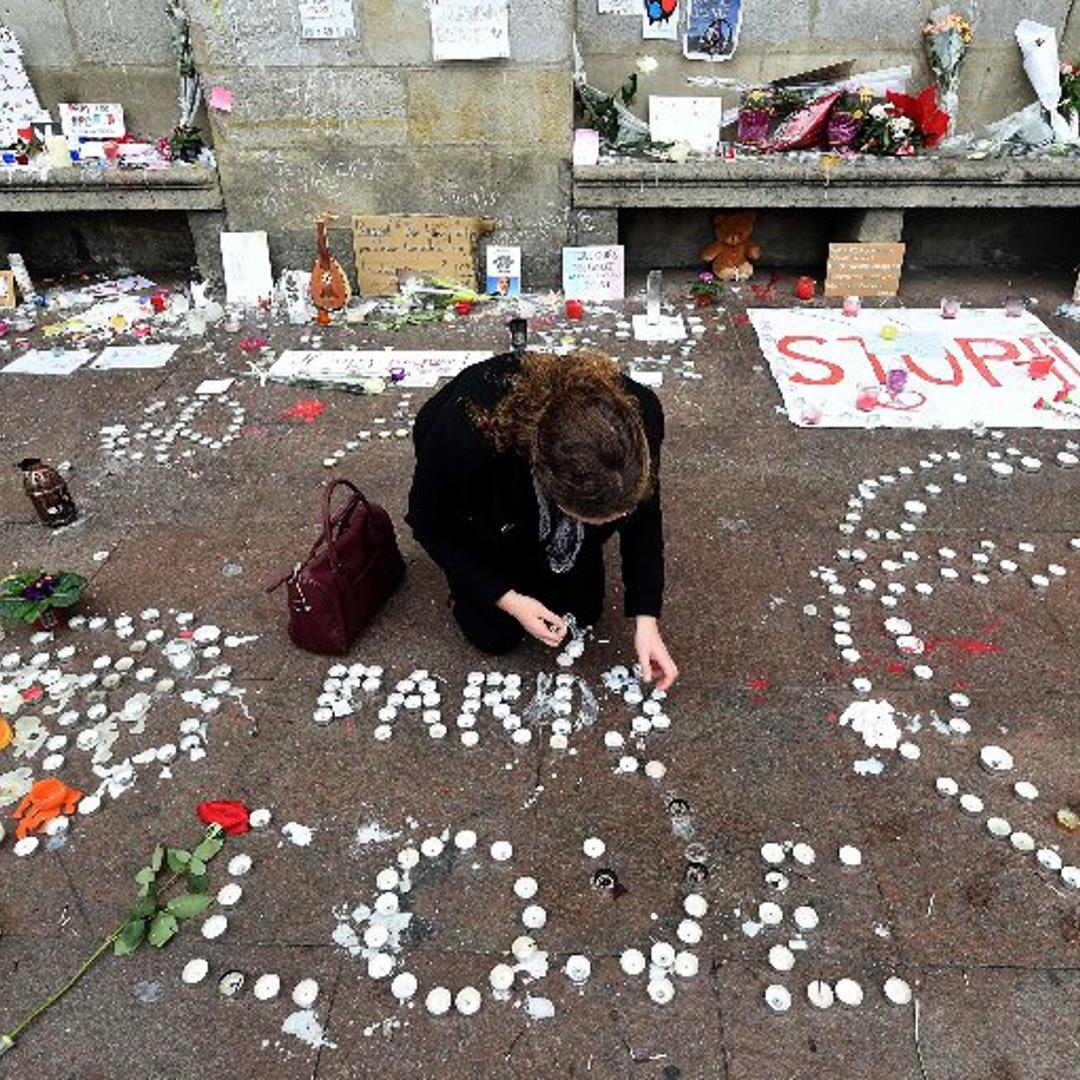 A woman lights candles during a minute of silence on Nov. 16, 2015 on the Place du Capitole in Toulouse to pay tribute to victims of the ISIS attacks on Paris.