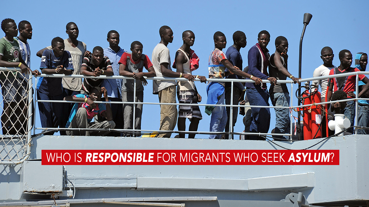 Immigrants, part of a group of more than 1,700 people, wait after they disembarked from the Italian military ship 'San Giusto' on August 11, 2014 in the port of Reggio Calabria, southern Italy, following Mare Nostrum rescue operations at sea. The Italian
