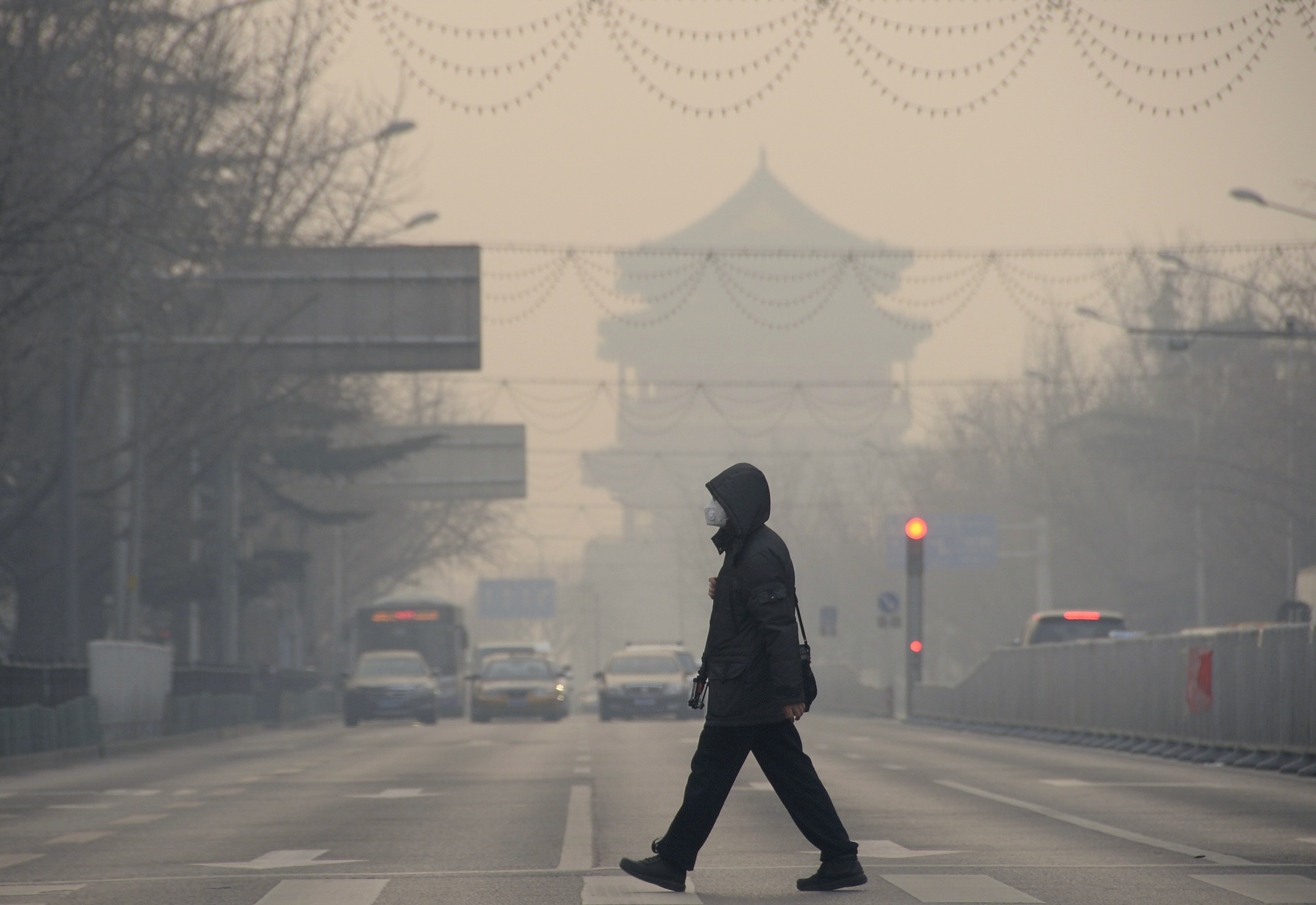 BEIJING, Dec. 29, 2015-- A pedestrian walks amid heavy smog in Beijing, capital of China, Dec. 29, 2015. A blue alert for heavy air pollution was issued by Beijing municipal emergency response headquarters. Beijing has been bothered by heavy pollution si
