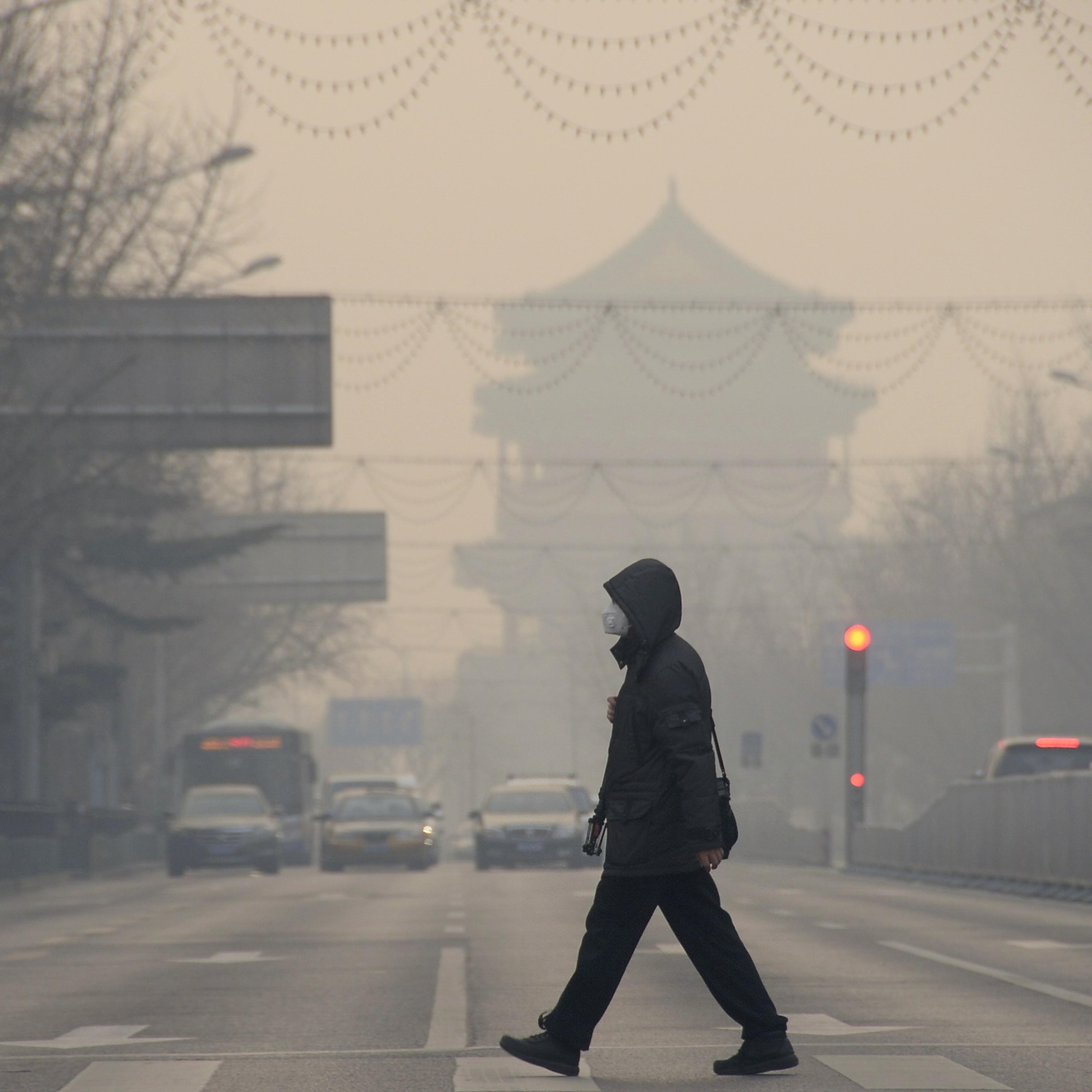 BEIJING, Dec. 29, 2015-- A pedestrian walks amid heavy smog in Beijing, capital of China, Dec. 29, 2015. A blue alert for heavy air pollution was issued by Beijing municipal emergency response headquarters. Beijing has been bothered by heavy pollution si
